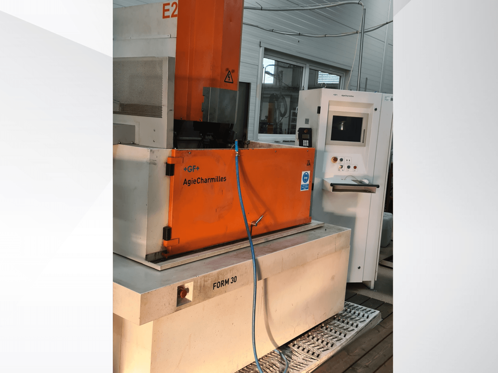AgieCharmilles FORM 30 die-sinking EDM machine, front view, with orange control cabinet and water hose visible.