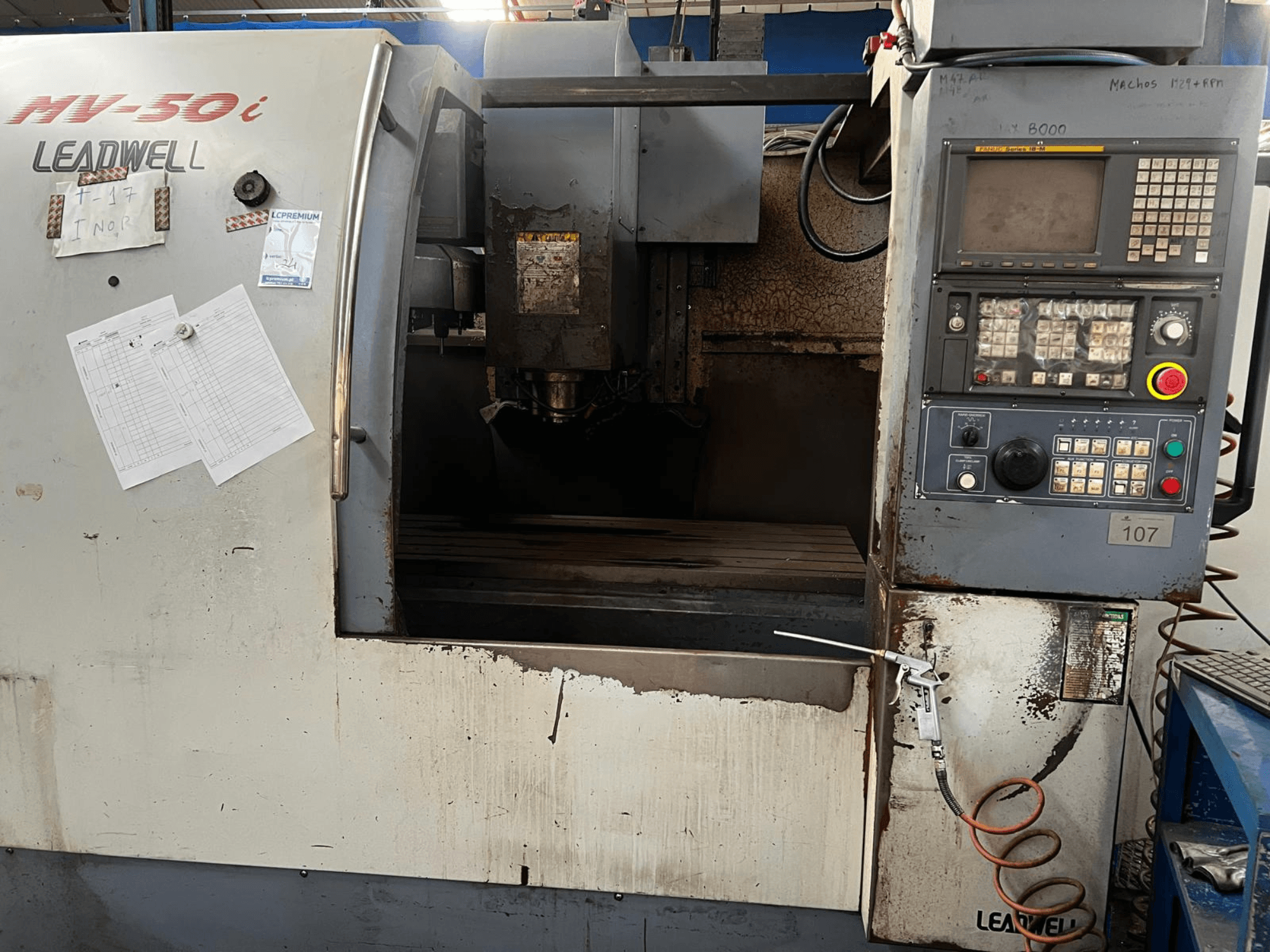 Leadwell MV-50i vertical machining center, front view, showing control panel, spindle area, and work table with wear.