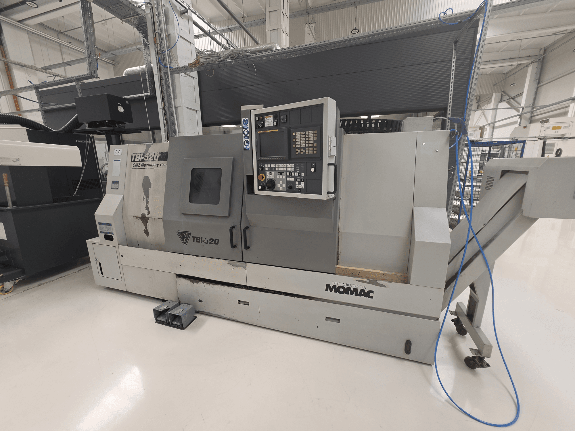 CMZ TBI-520 horizontal turning machine, side view, showing control panel and machinery details in a clean industrial setting.