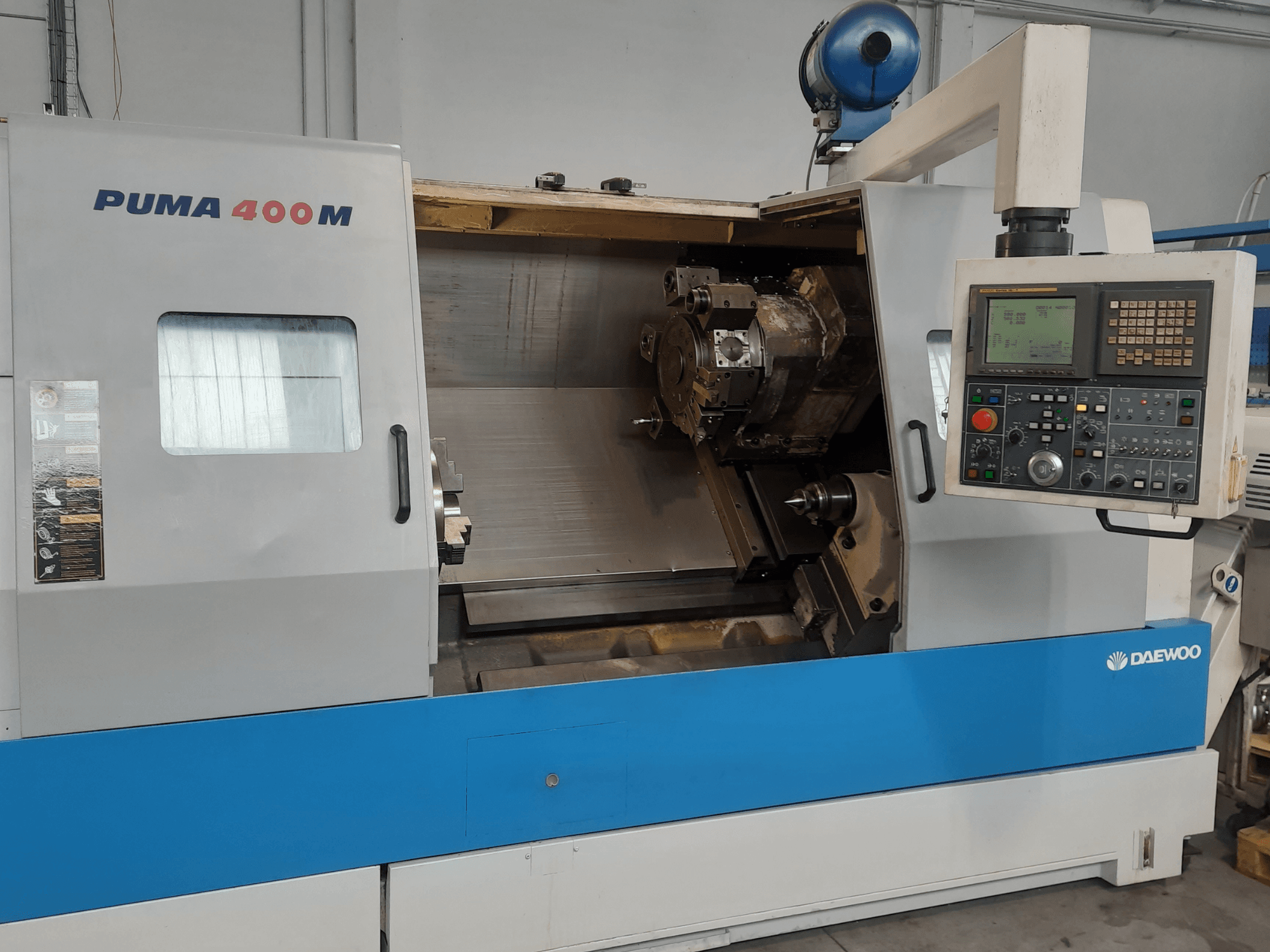 Front view of a DAEWOO PUMA 400MB horizontal turning machine, showcasing controls and cutting tool in the chamber.