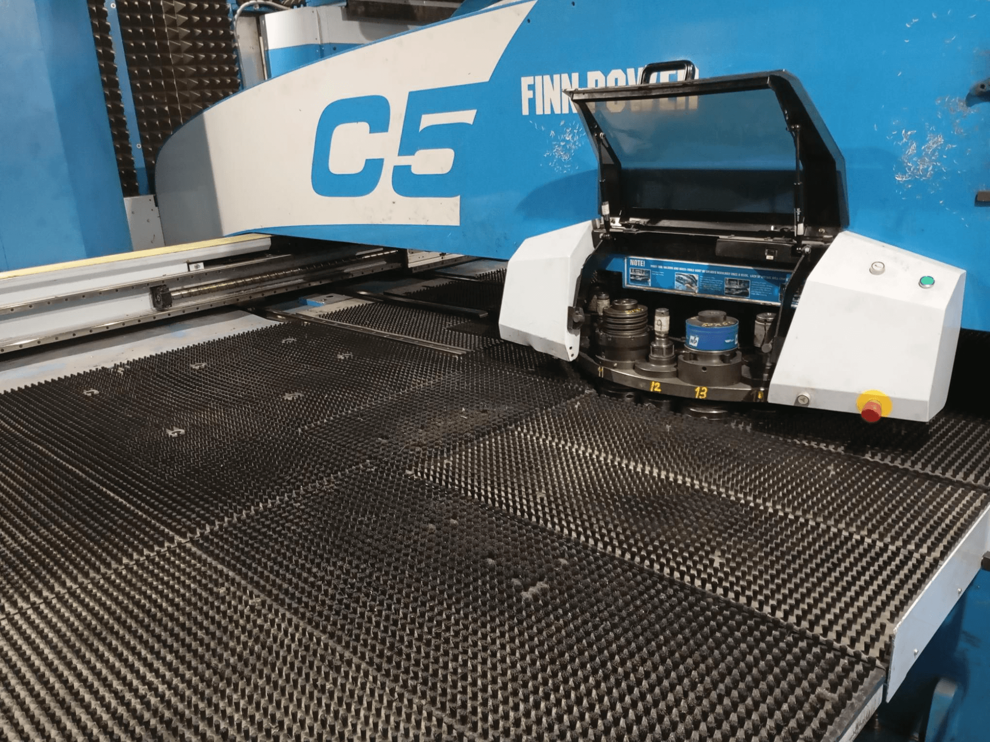 Finn-Power C5 punch press, front view, showing the tool head open over a textured work table with numbered indexing points.