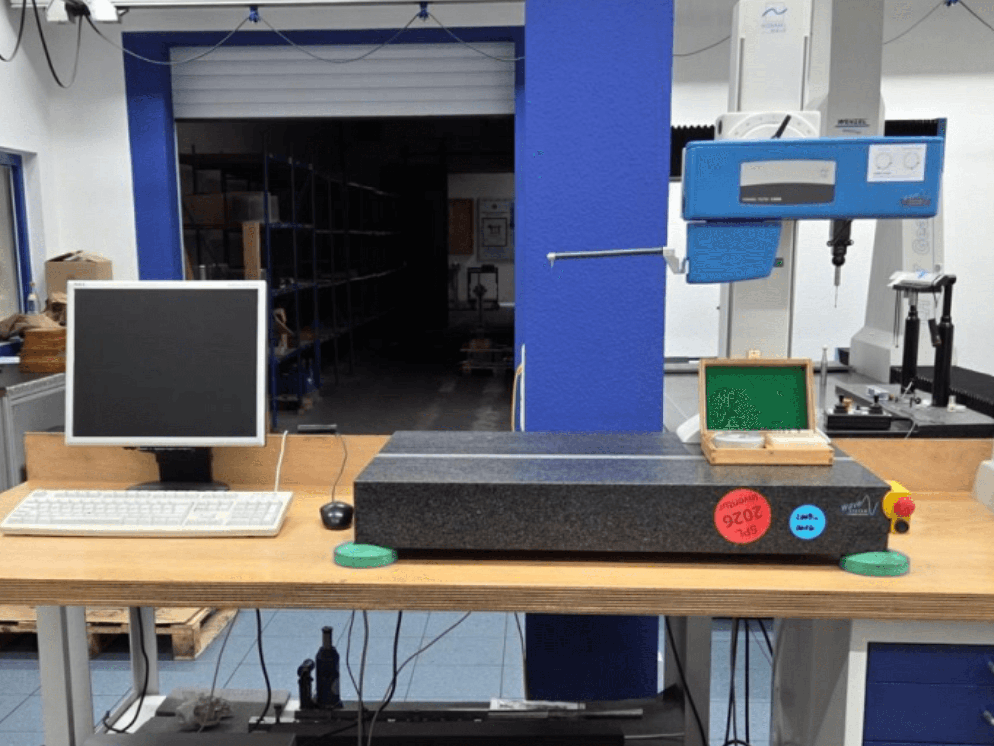 JENOPTIK wave C8000 CMM in a workshop, featuring a monitor, keyboard, and granite measuring surface. Front view.