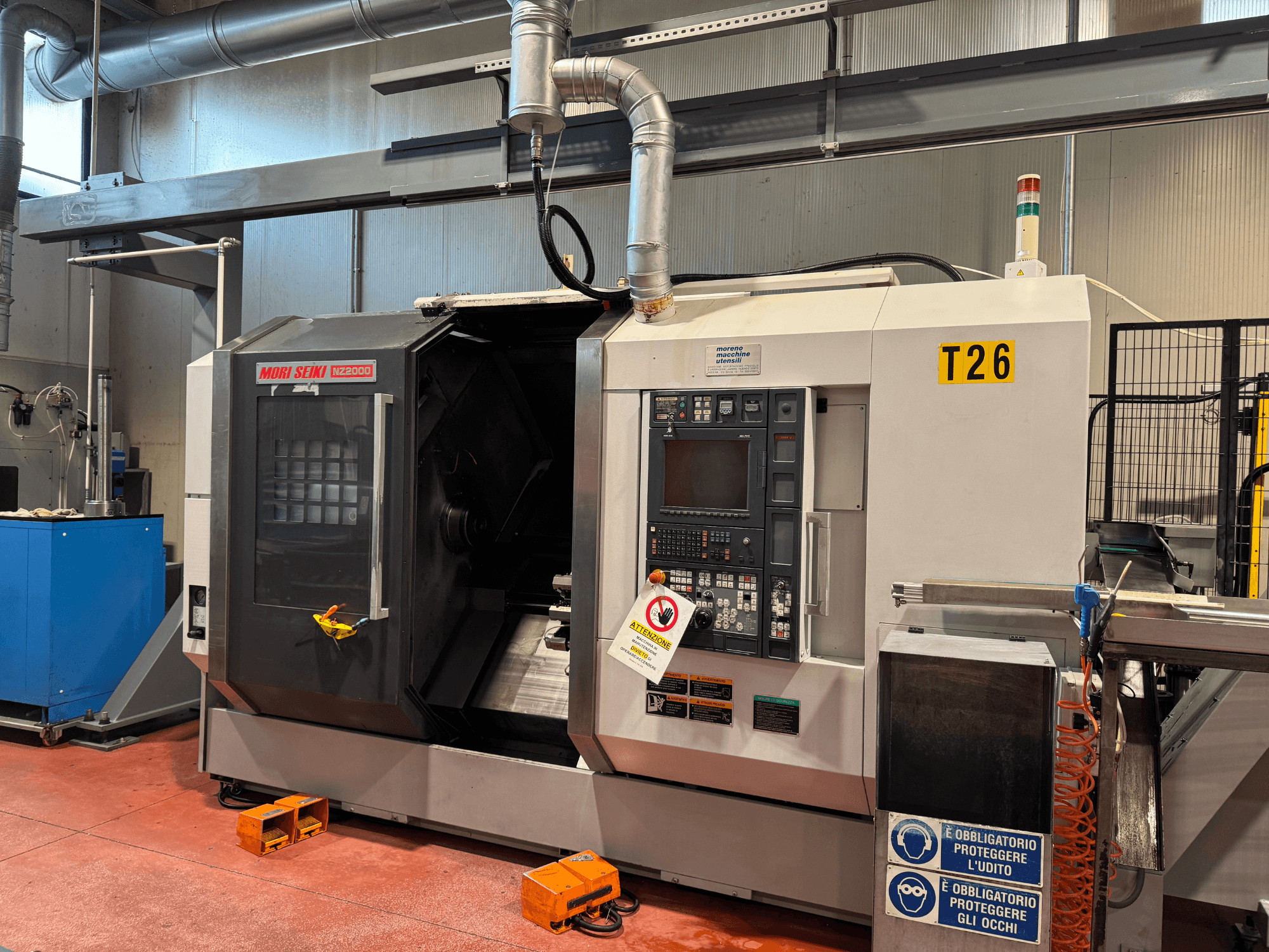 MORI SEIKI NZ-2000/T2/Y2 turn-mill centre, front view, features control panel, safety signage, and industrial setup.
