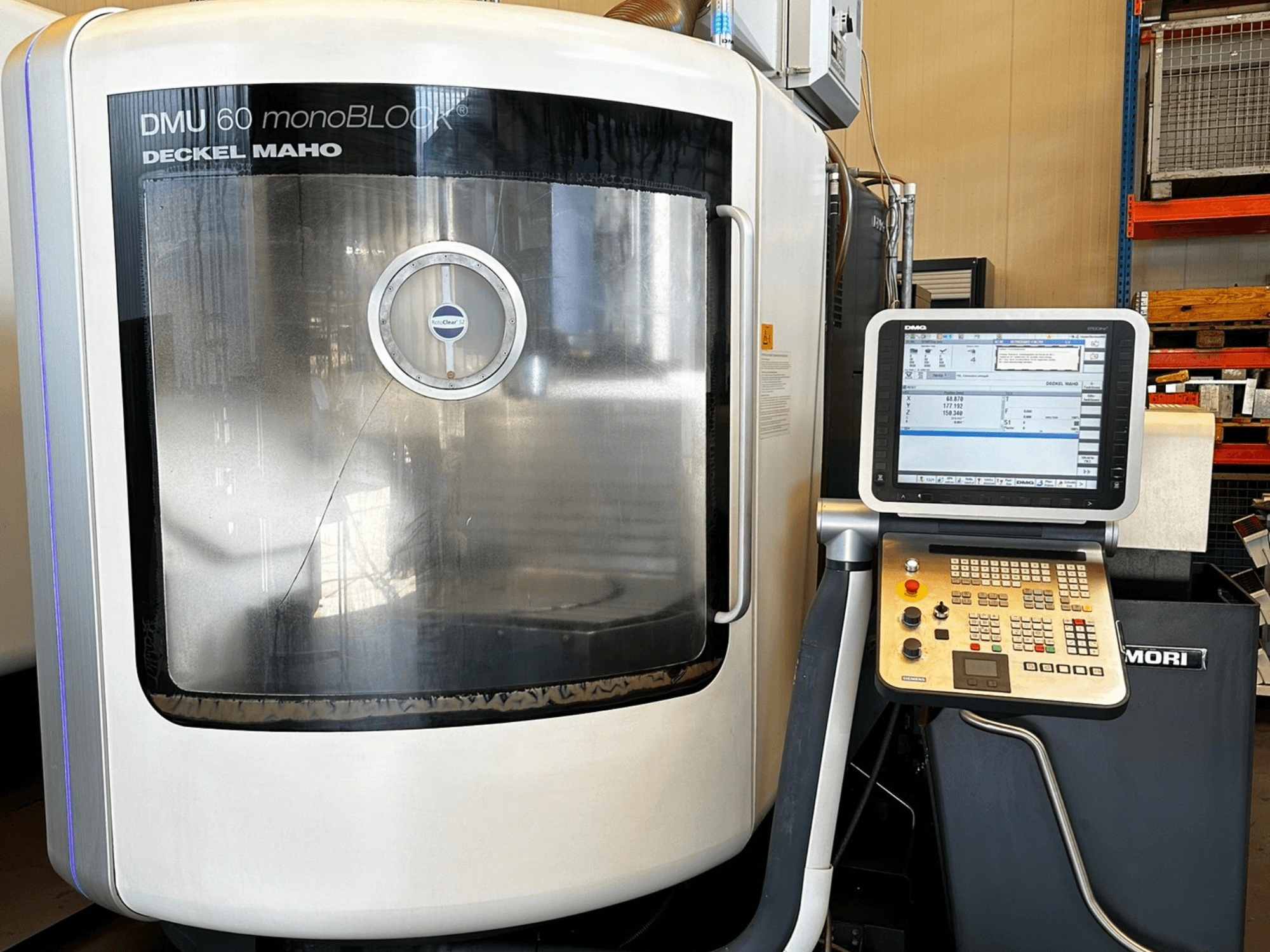 DMG MORI DMU 60 monoBLOCK vertical machining center, front view, showing touchscreen control panel and reflective window.