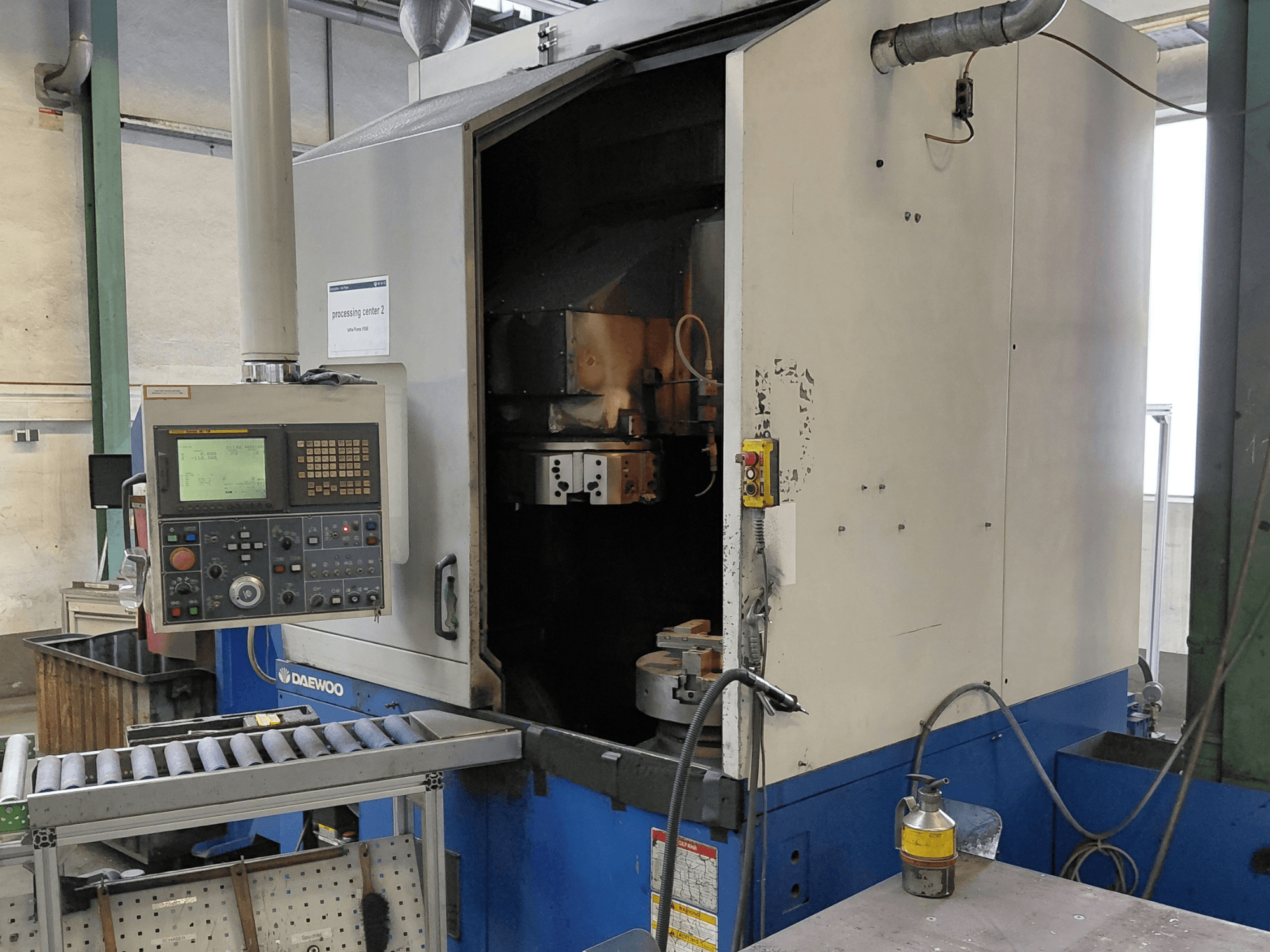 Daewoo Puma V550 vertical turning machine, front view showing control panel, spindle, and coolant connection.