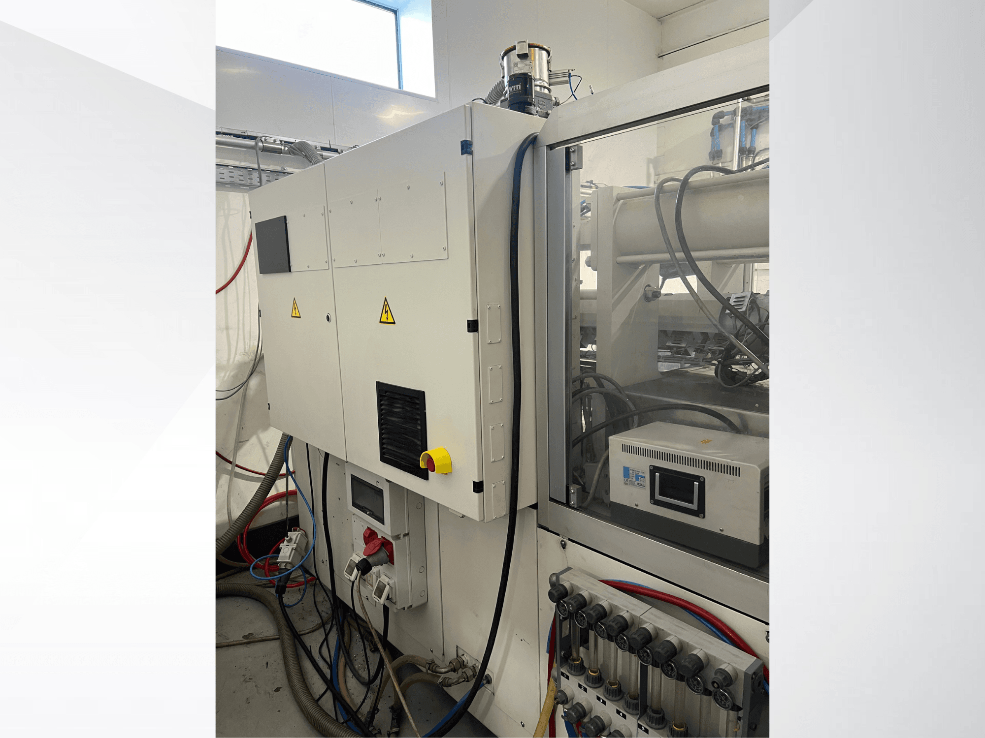 Krauss Maffei 125-520 C1 hydraulic injection moulding machine, side view showing control panel and hydraulic connections.