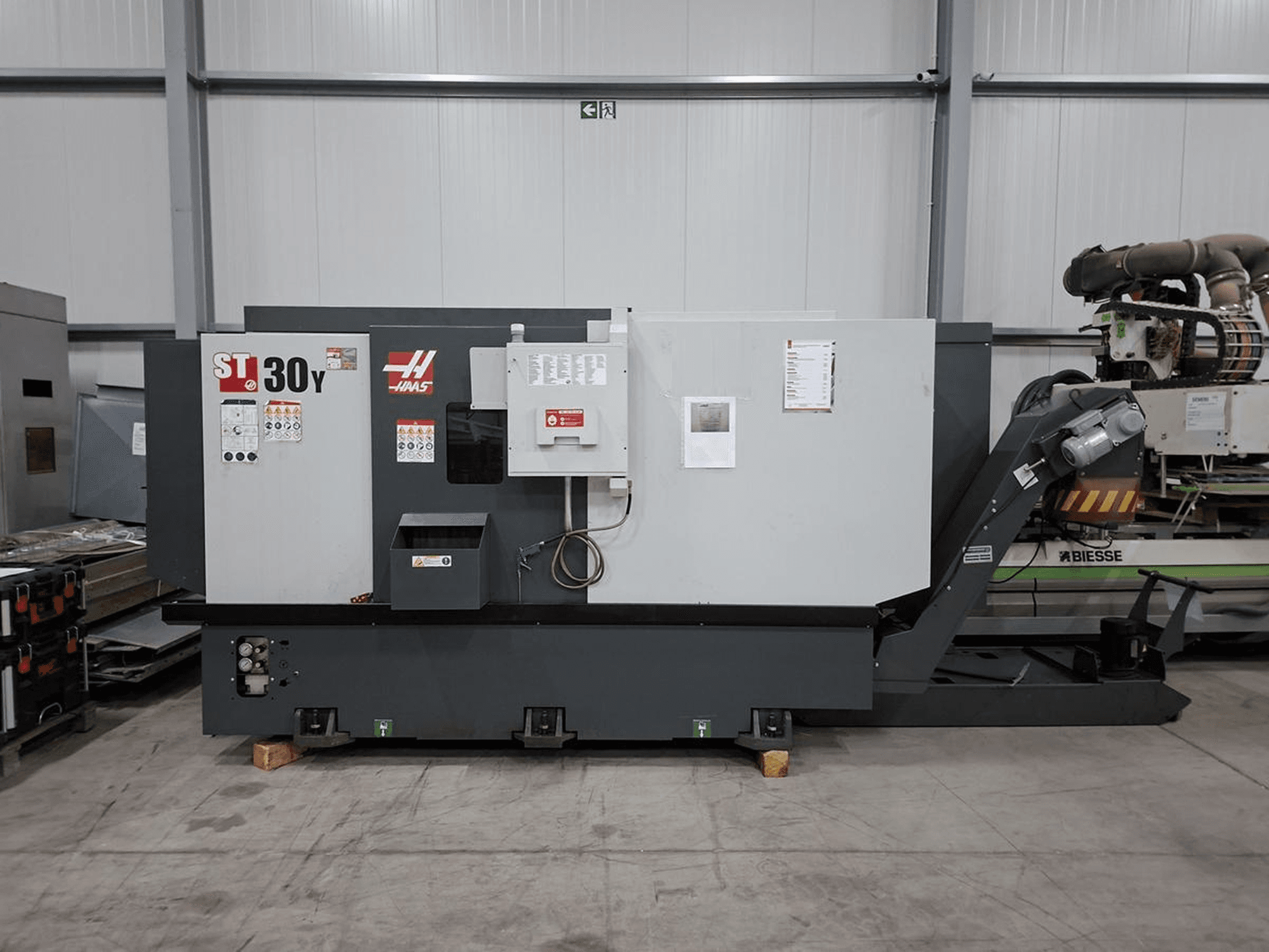 Haas ST-30Y horizontal turning machine in side view, displaying controls, labels, and a robust build in a spacious workshop.