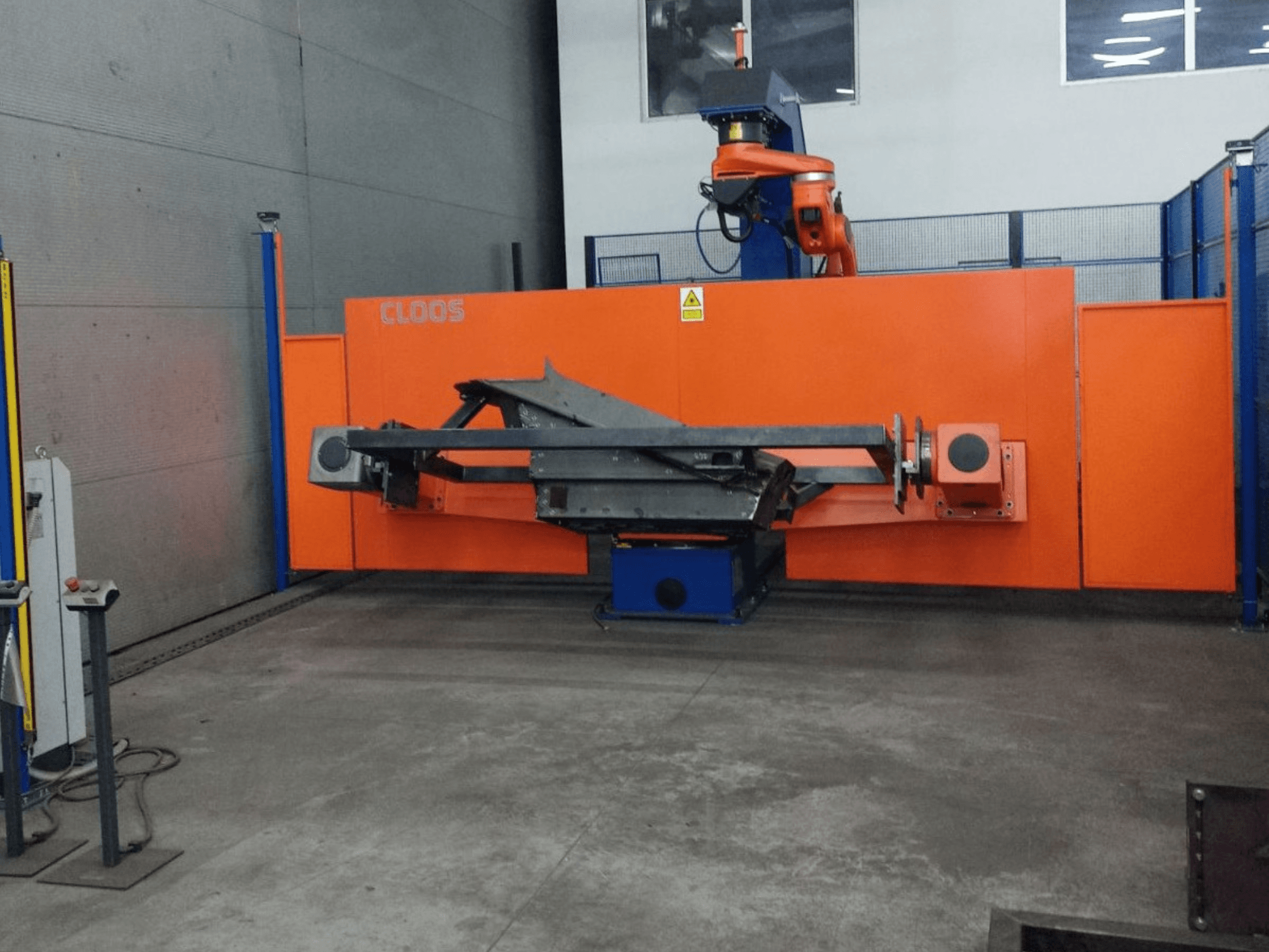 Front view of CLOOS QIROX QRC-350-E automation system with robotic arm and metalwork structure in industrial setting.