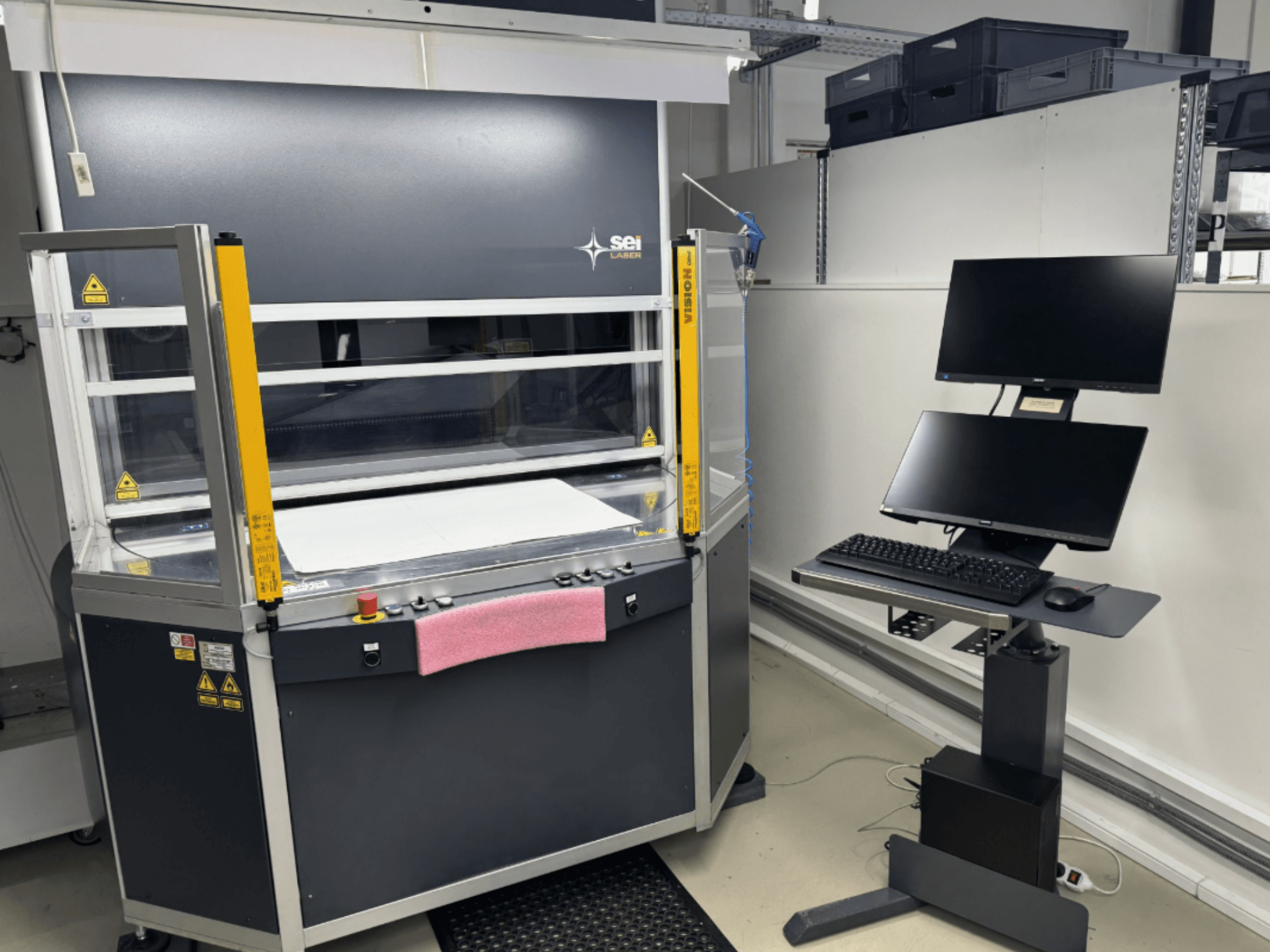 SEI Laser INFINITY 5070 V300 CO2 laser cutting machine in front view, with control panel and attached monitor station.