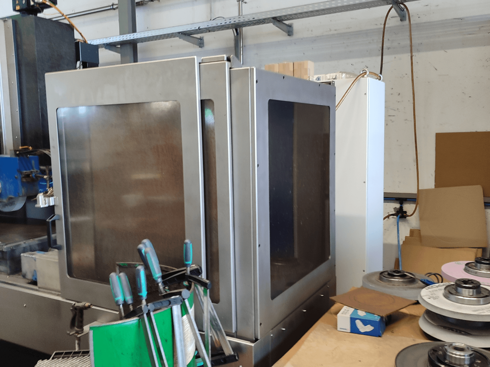 HEINZ STÖCKEL FD 1560 NC-T surface grinding machine, side view showing metal casing and grinding components in workshop setting.