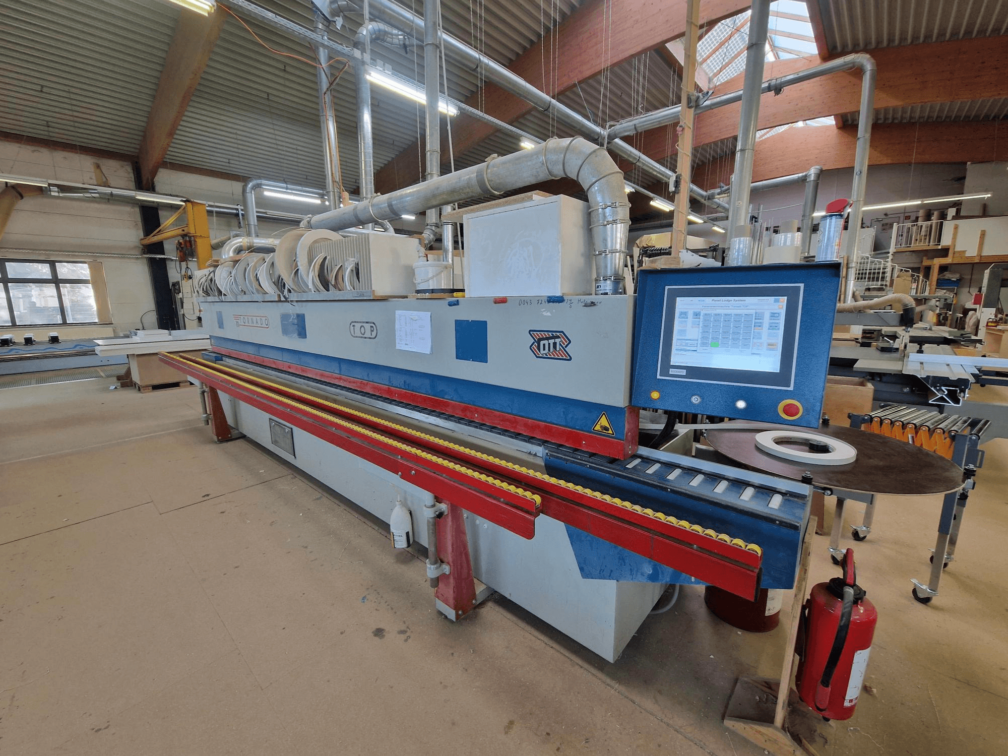 OTT Tornado edgebander, front view, showcasing the control panel, feed rollers, and adhesive application area.