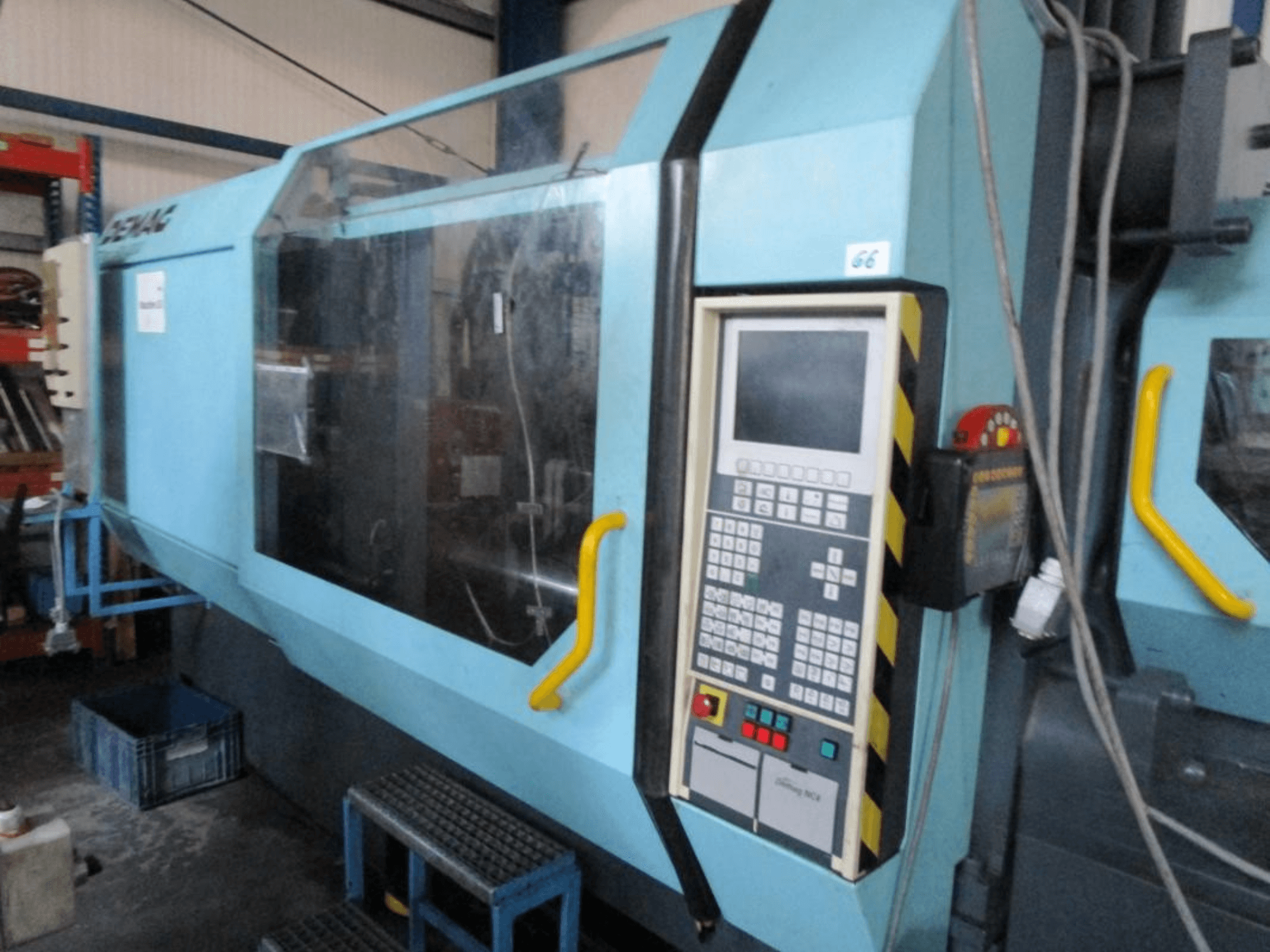 Demag Erdotech 500-3300 hydraulic injection moulding machine, front view, features control panel and clear safety enclosure.