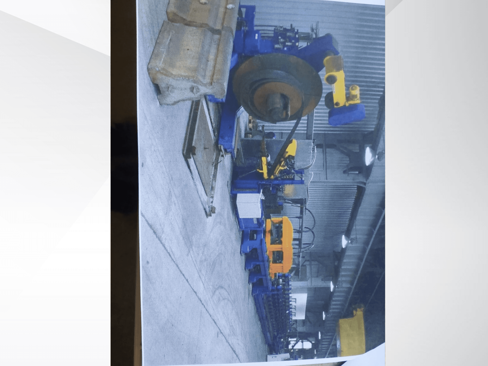 Müller Profilierung 3 profile bending machine in a workshop, showcasing blue structure and yellow hydraulic components.