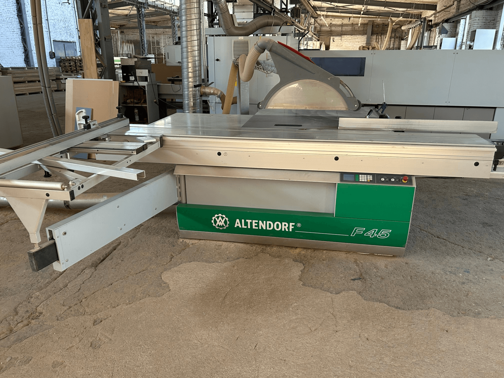 Altendorf F 45 panel saw, front view, showing the cutting table, blade guard, and control panel on the green and gray machine.