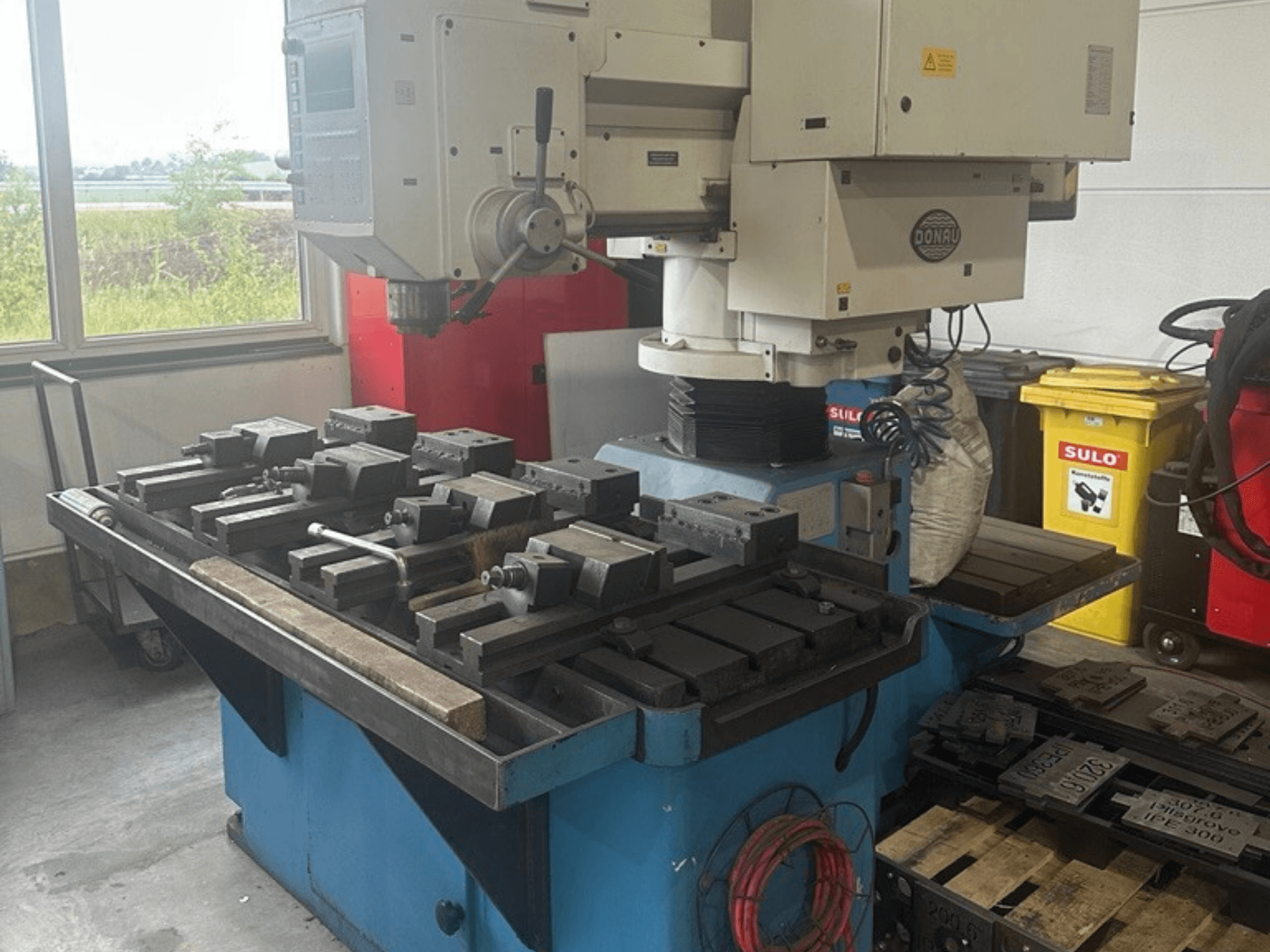 DONAU Danumeric 440 vertical machining centre in a workshop, featuring a tool table and various attached components.