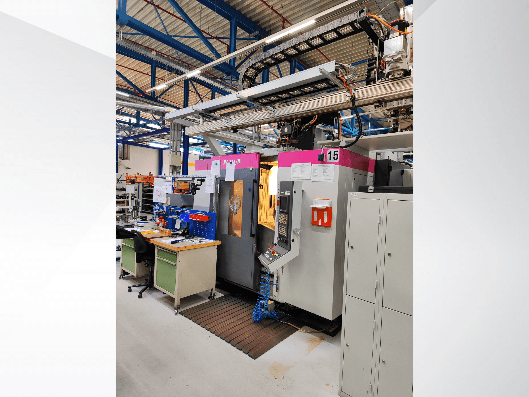 STAMA MC 734M vertical machining center in a workshop; front view showing control panel and storage cabinet.