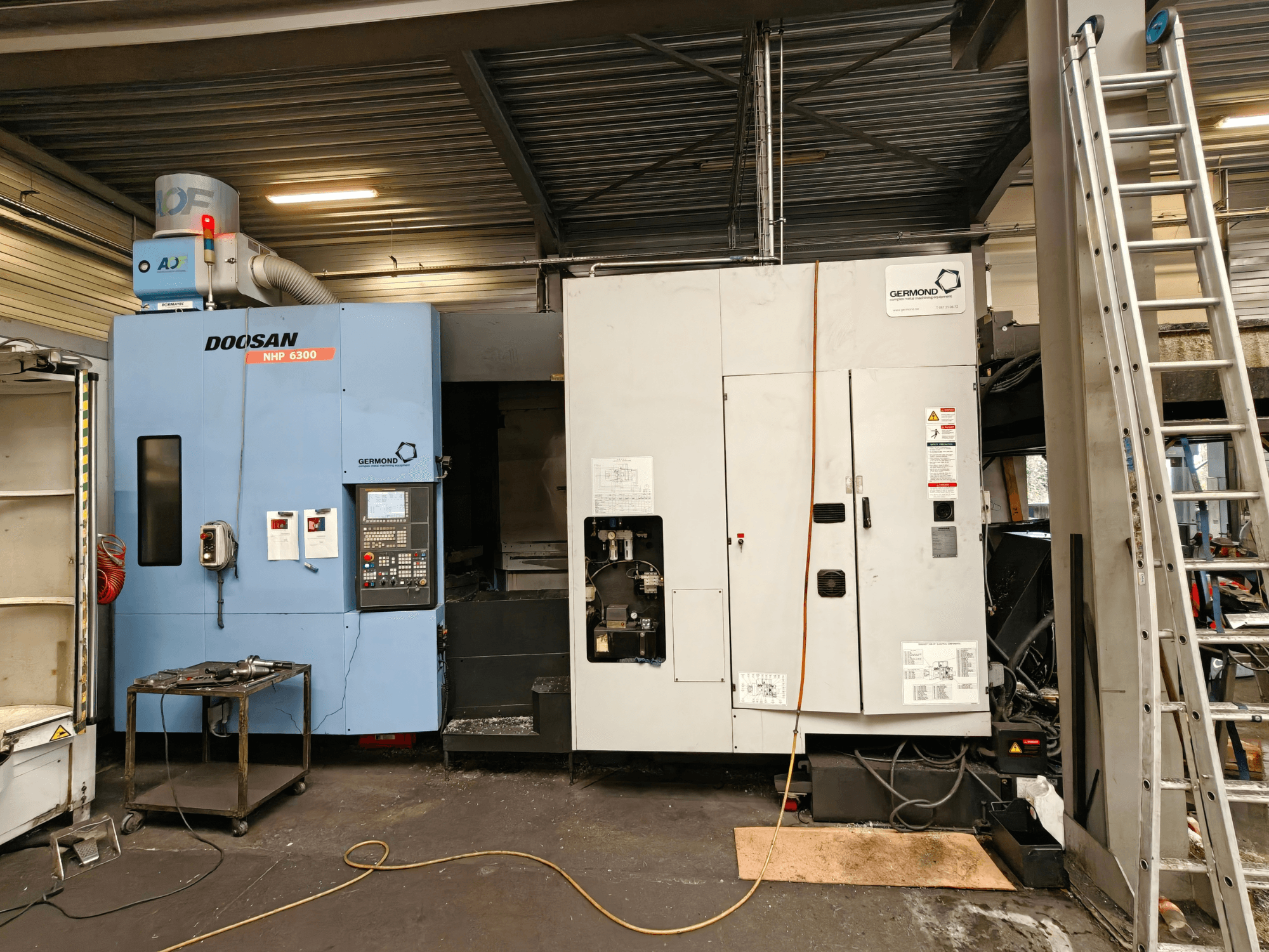 DOOSAN NHP6300 horizontal machining center in front view, showcasing control panel and adjacent machinery in a workshop setting.
