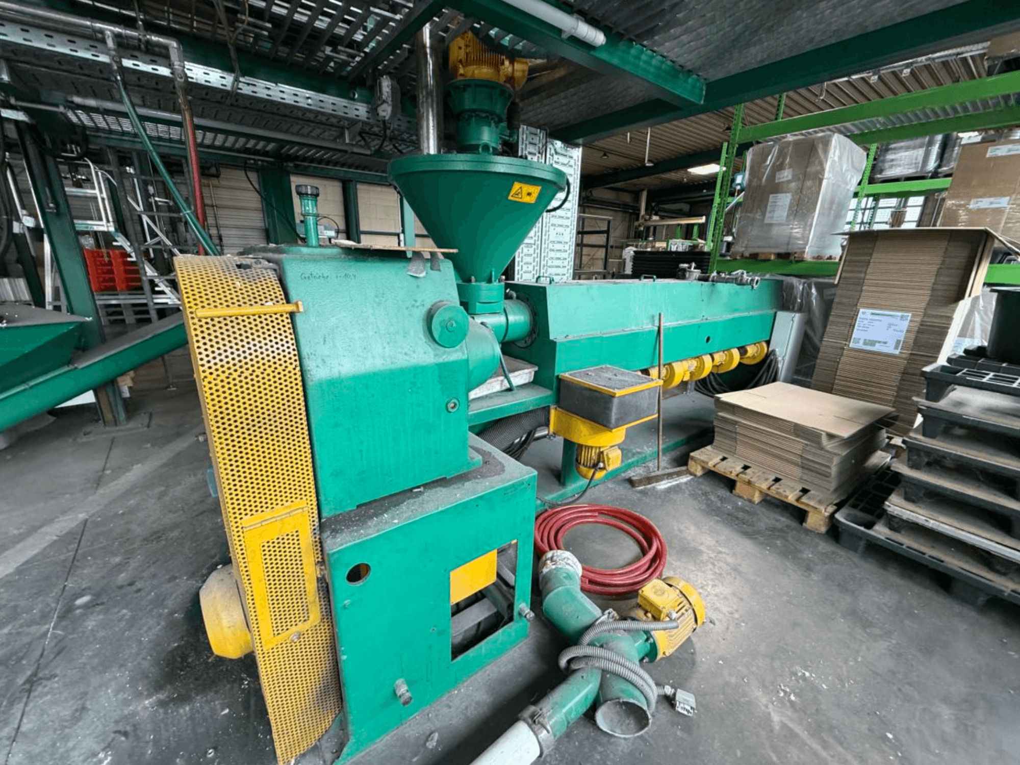 Single screw extruder Prealpina 105 by Other, shown in side view; features green casing, conveyor attachments, and adjacent materials.