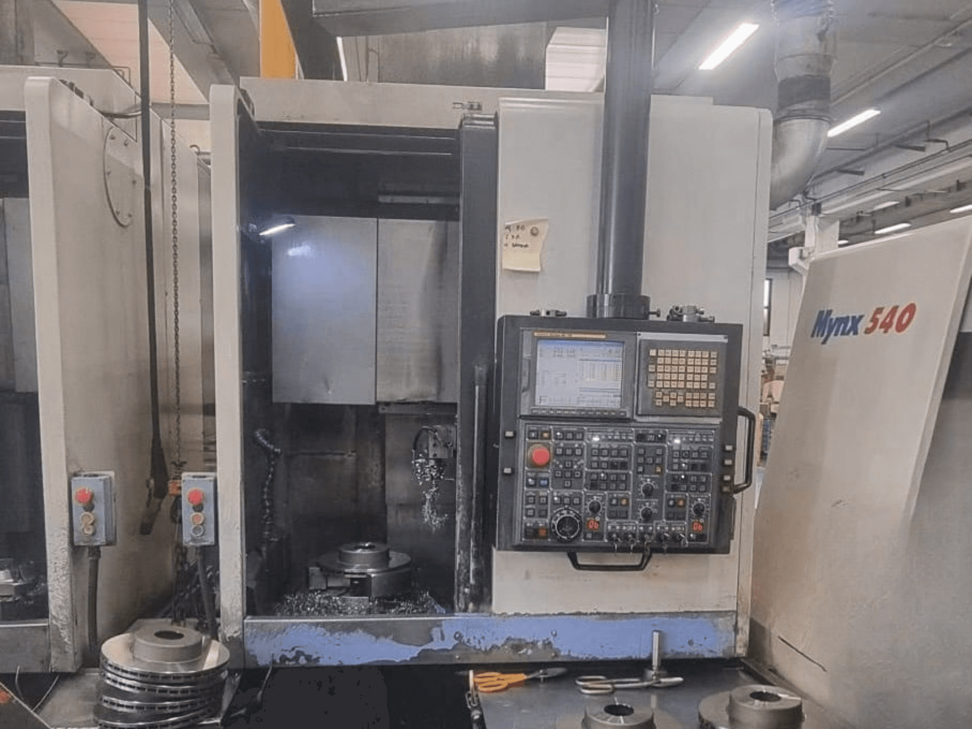 Front view of a DOOSAN PUMA V400-2SP vertical turning machine, showing control panel and workpiece setup inside the machine.