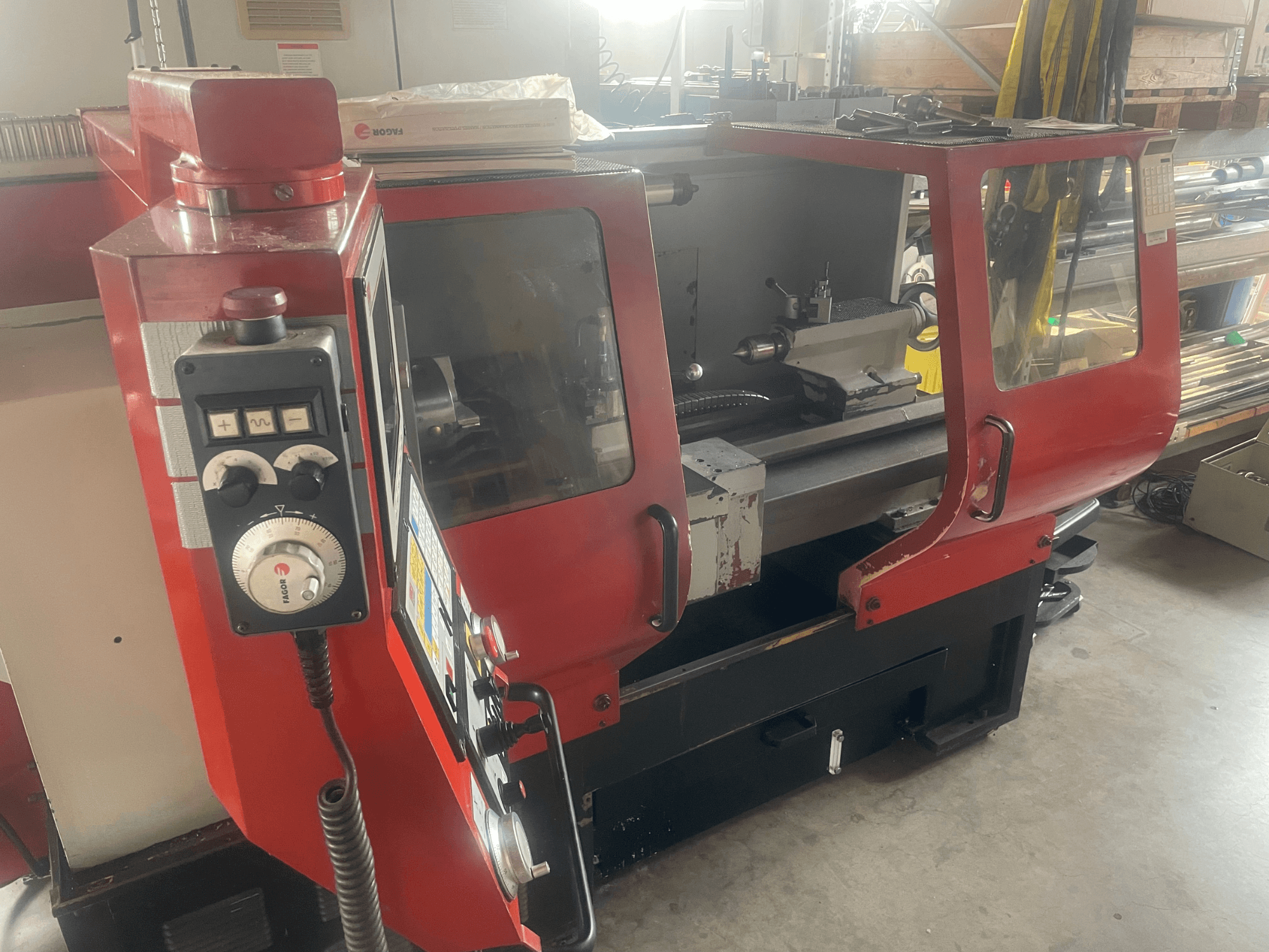 EMCO EMCOMAT 200X1000 horizontal turning machine, side view, showing controls, windowed enclosure, and lathe setup.