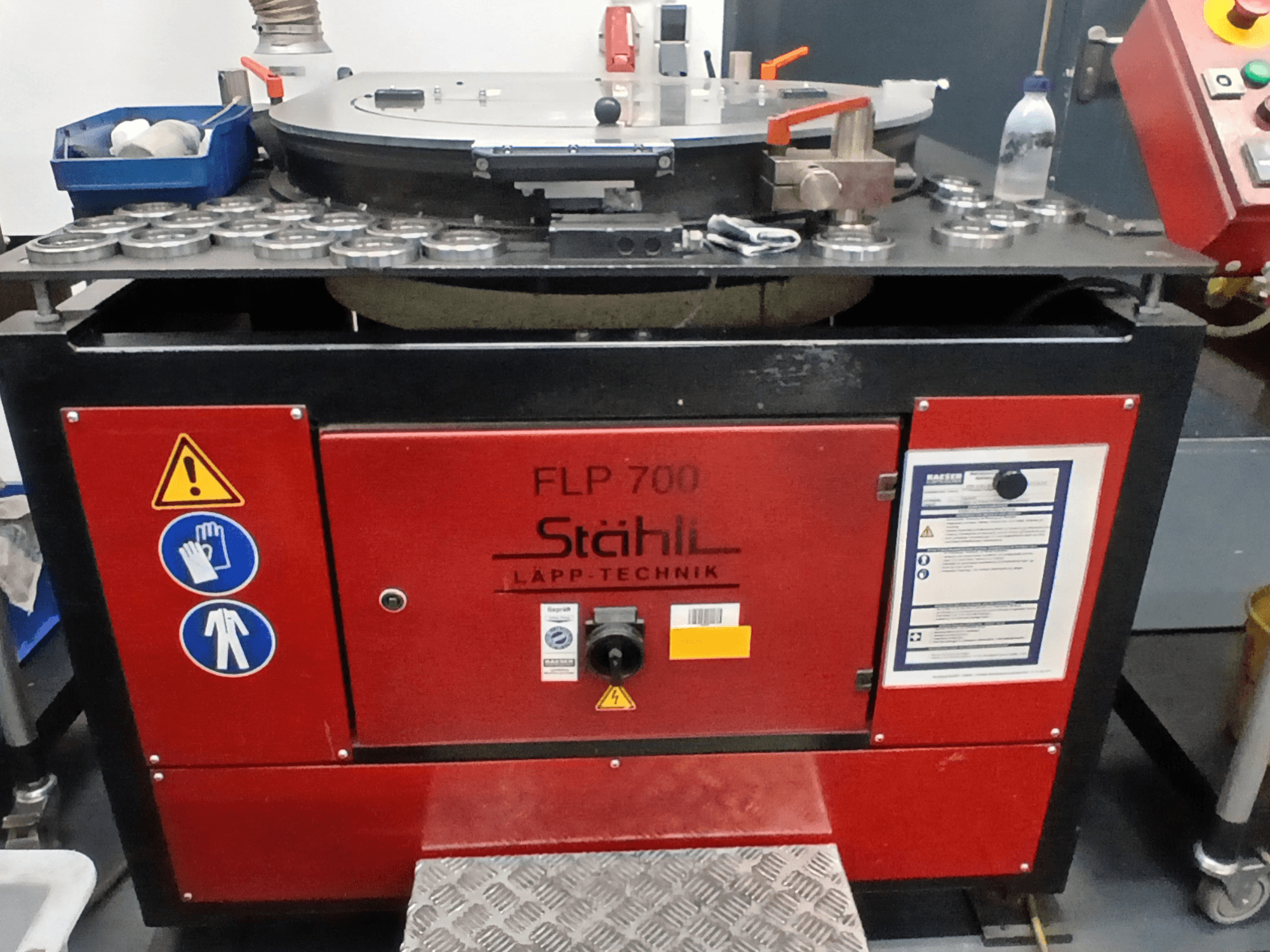 STAHLI FLP 700 machine tool, front view, featuring operational controls, safety warnings, and components on a metal surface.