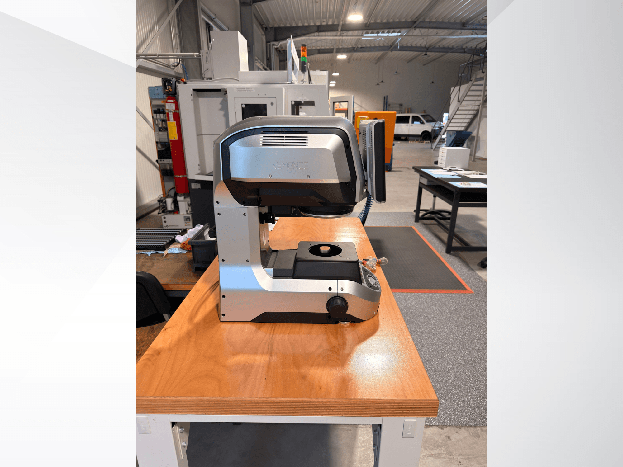 Front view of KEYENCE IM-8005 Optical Measurement Machine on a wooden table, showcasing its sleek design and operational interface.