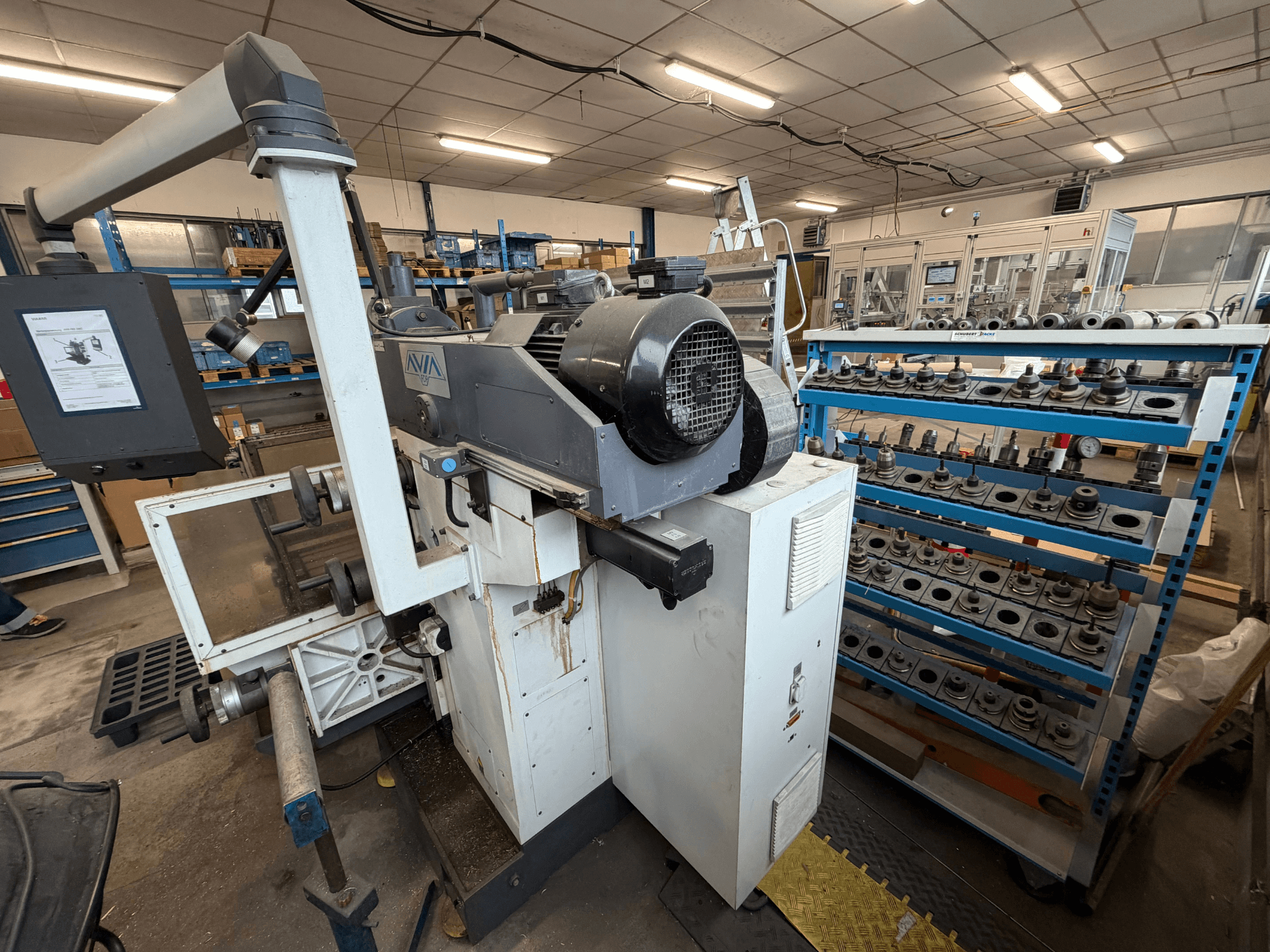 Avia FNX30NC Universal Machining Centre, front view showing controls and tool storage area with components in background.