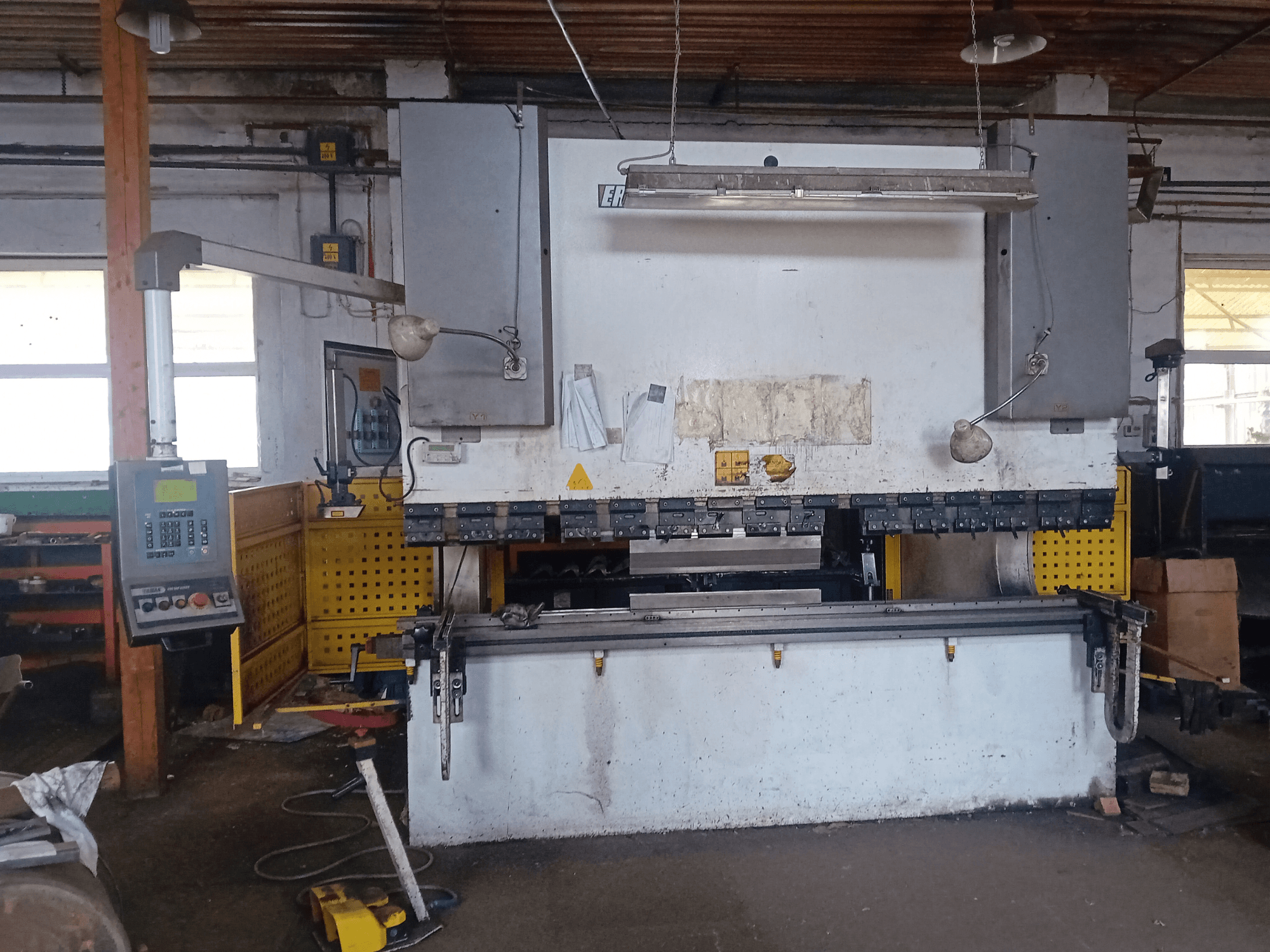 ERMAK CNC HAP 3100x300 hydraulic press shown in front view, featuring control panel and workbench in a workshop setting.