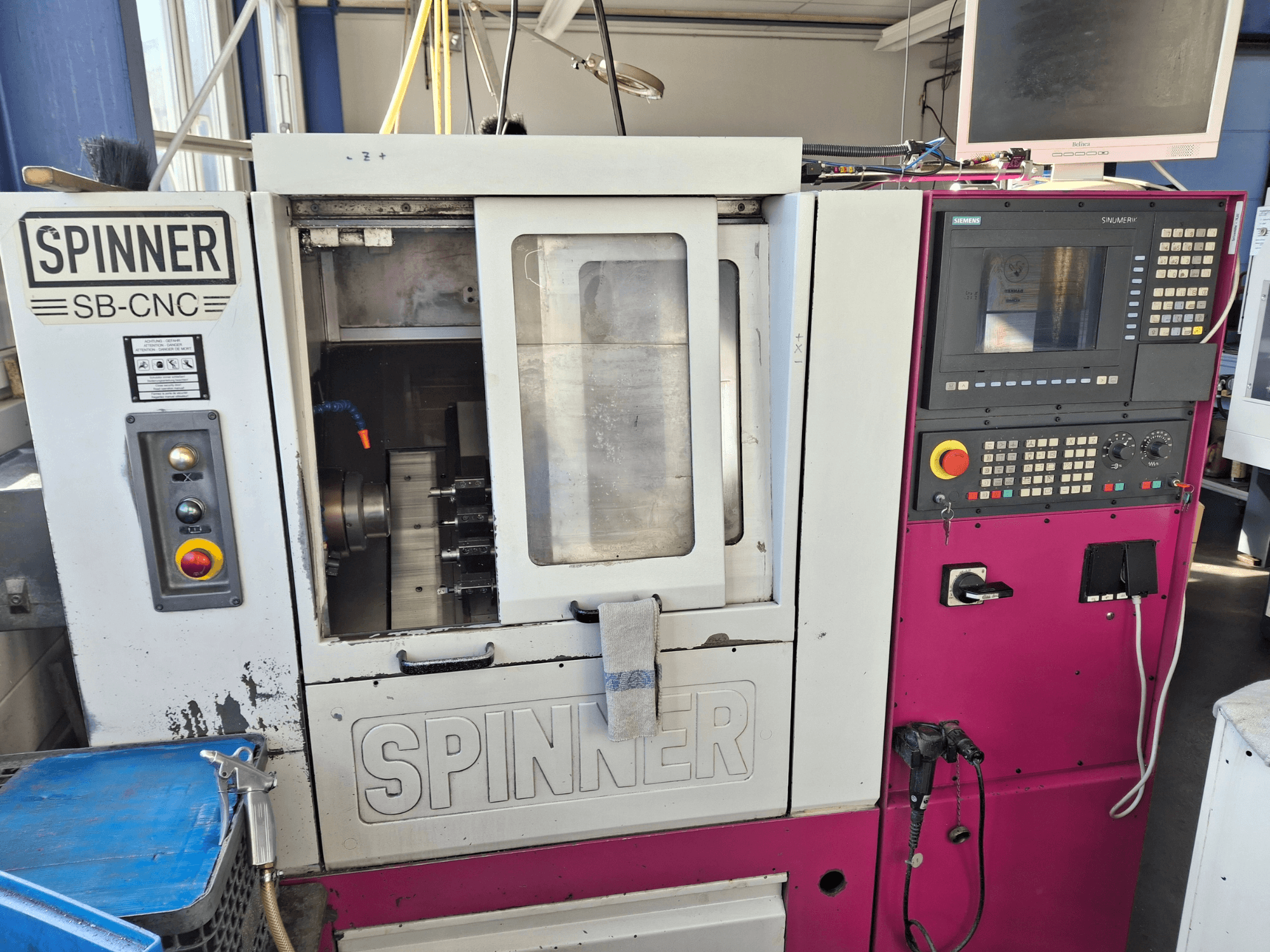 Horizontal turning machine SPINNER SB-CNC, front view showing control panel, tool holder, and operational indicators.