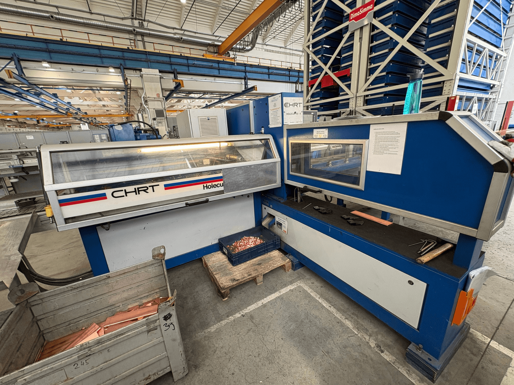 CNC punching machine EHRT Holecut 40-9, front view, with control panel, metal bin, and copper sheets nearby.