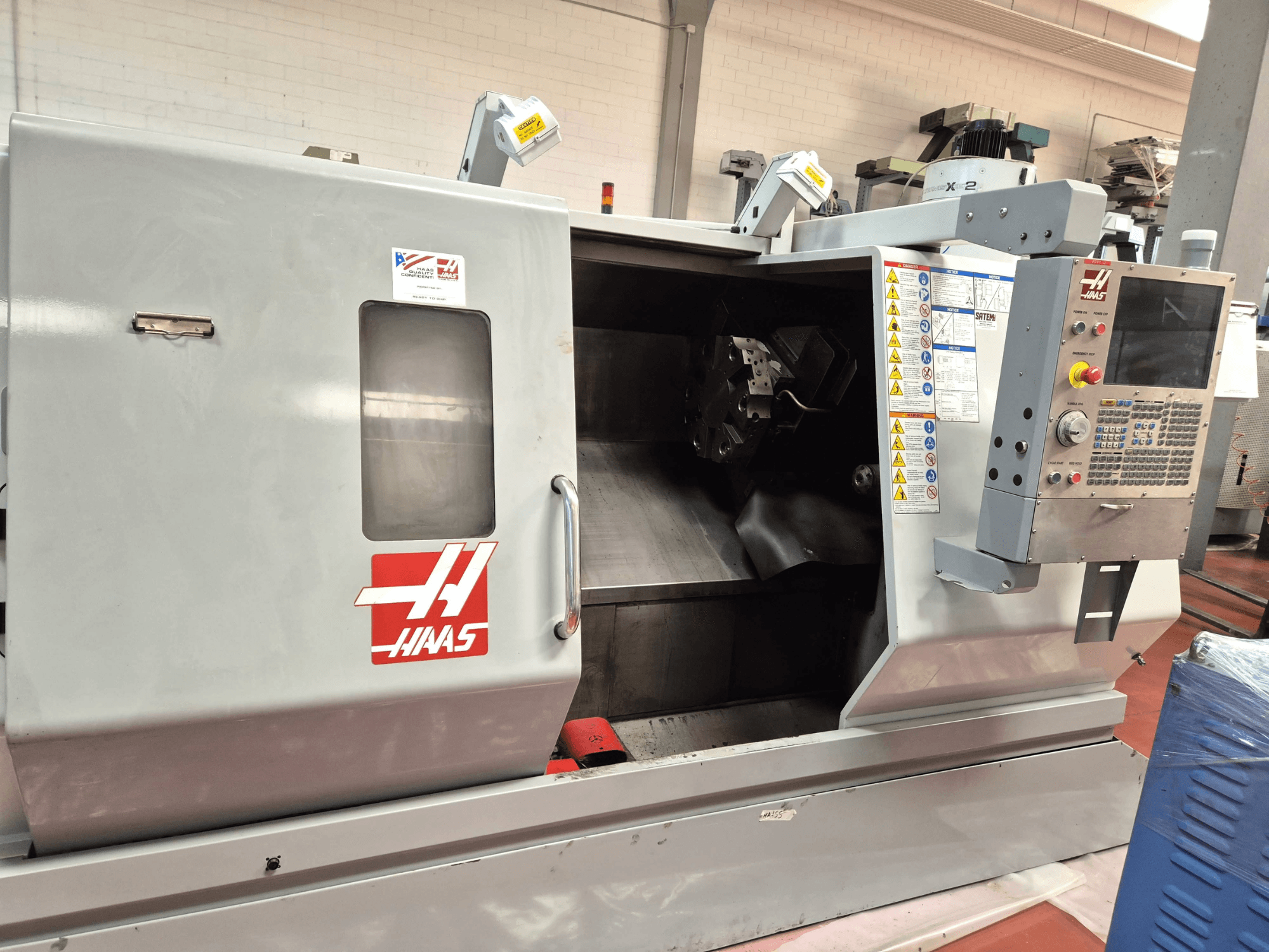 Haas SL 30TBHE horizontal turning machine, front view showcasing controls and open compartment for machining operations.
