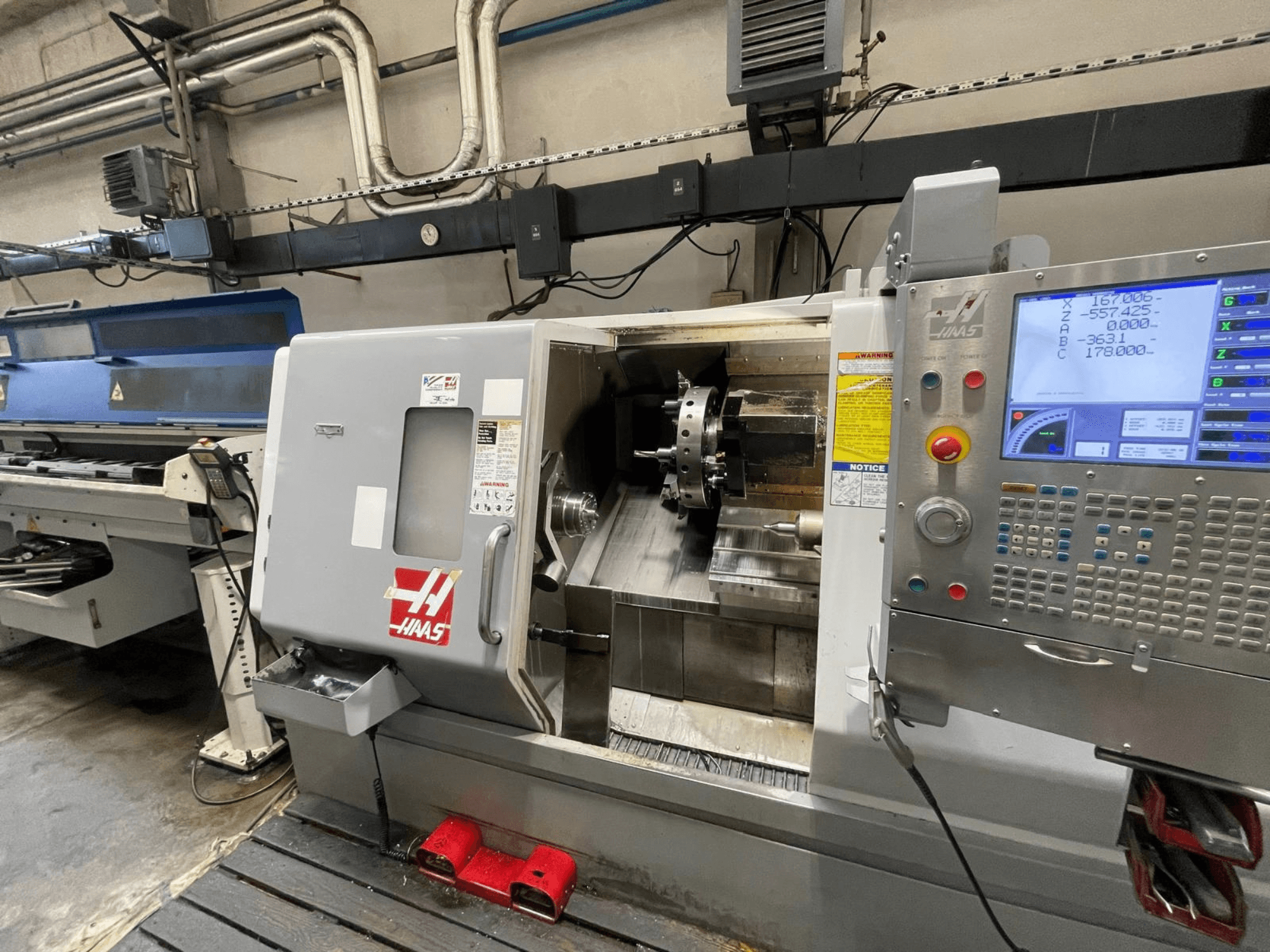 Haas SL-30THE horizontal turning machine in a workshop, featuring a digital control panel and exposed work area.