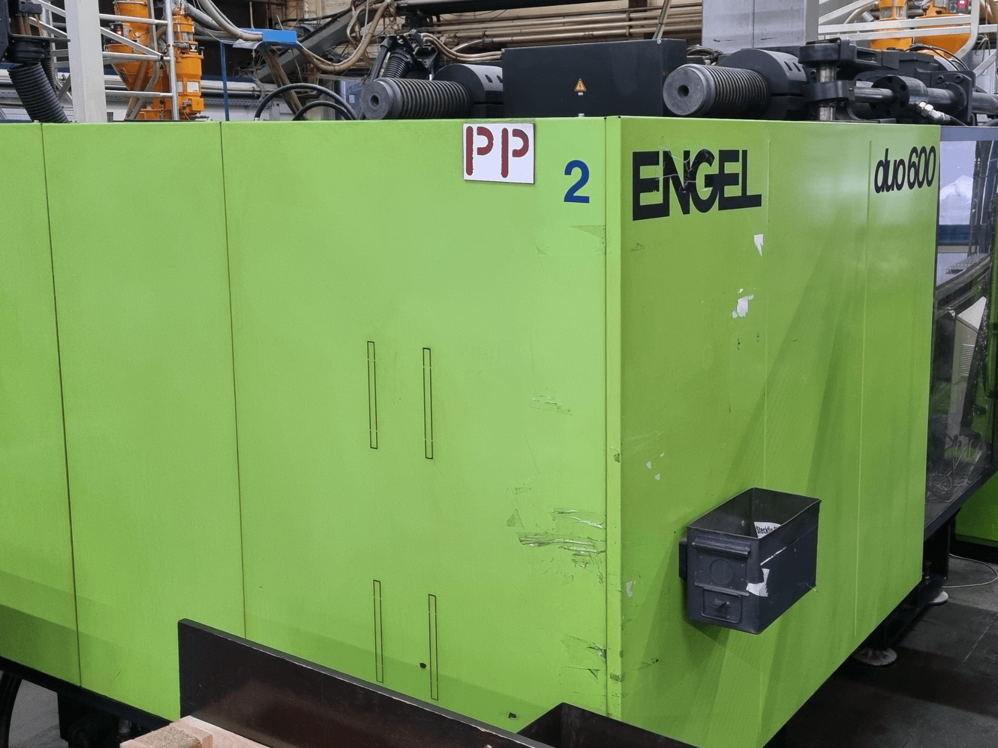 Engel duo 600 hydraulic injection moulding machine, green exterior, front view, features labeled parts, and material storage box.