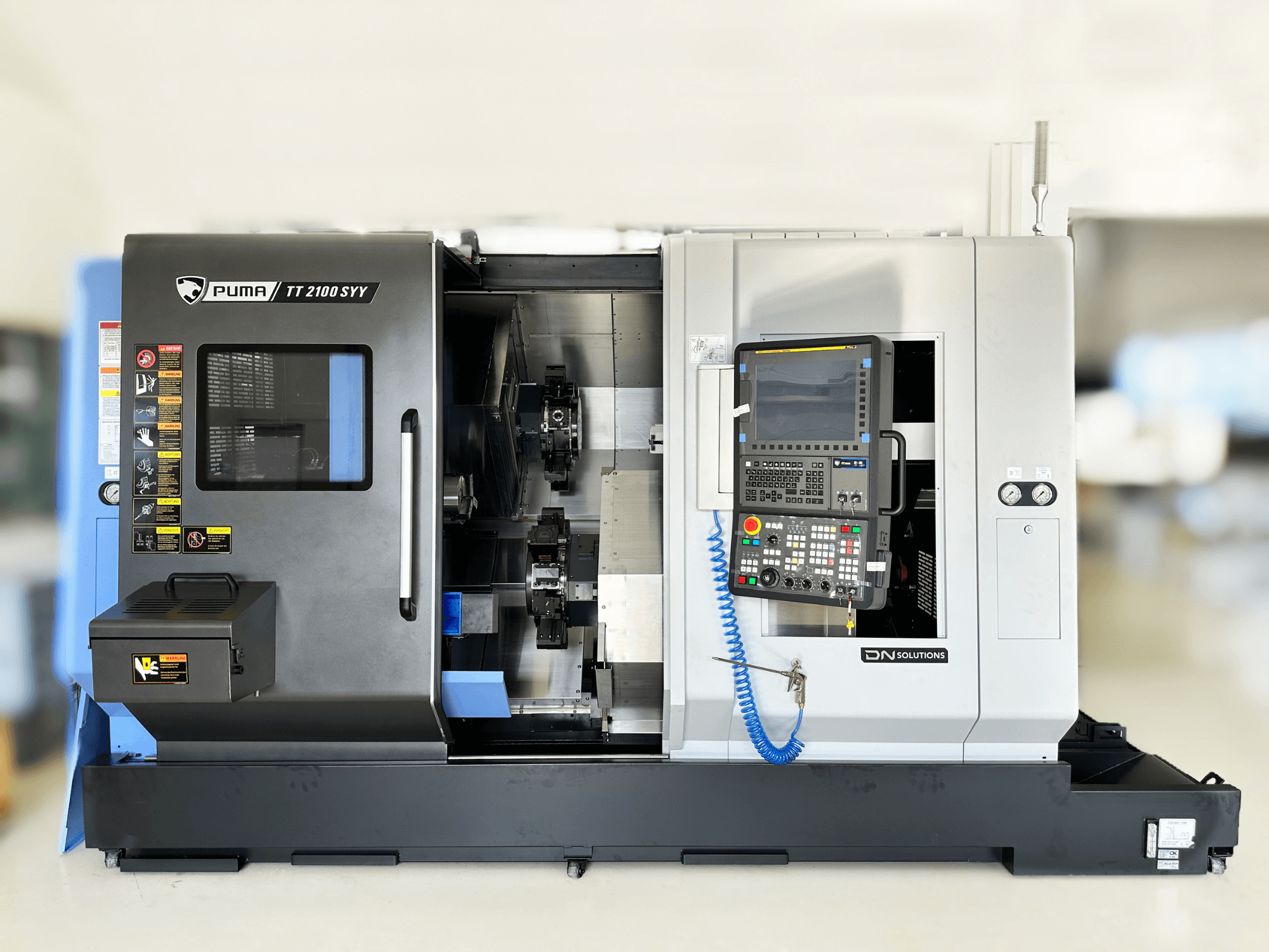 Turn-Mill Centre DN SOLUTIONS PUMA TT2100SYY front view, featuring a control panel and visible interior components.