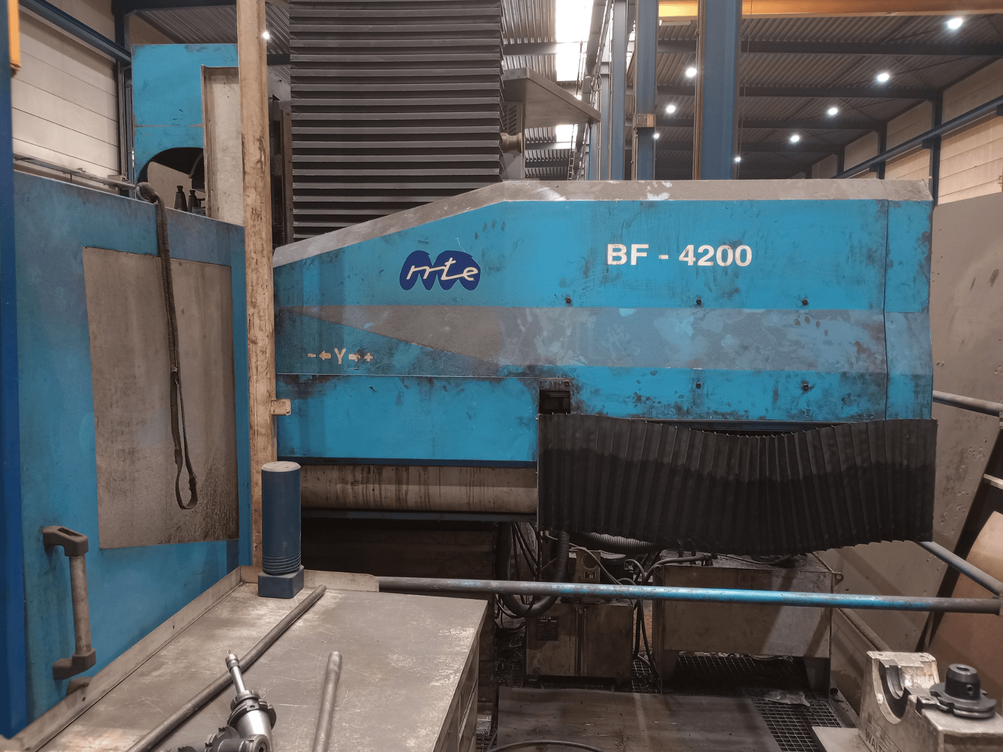 MTE BF 4200 bed type milling machine, side view, showing blue exterior and detailed machine components in a workshop setting.