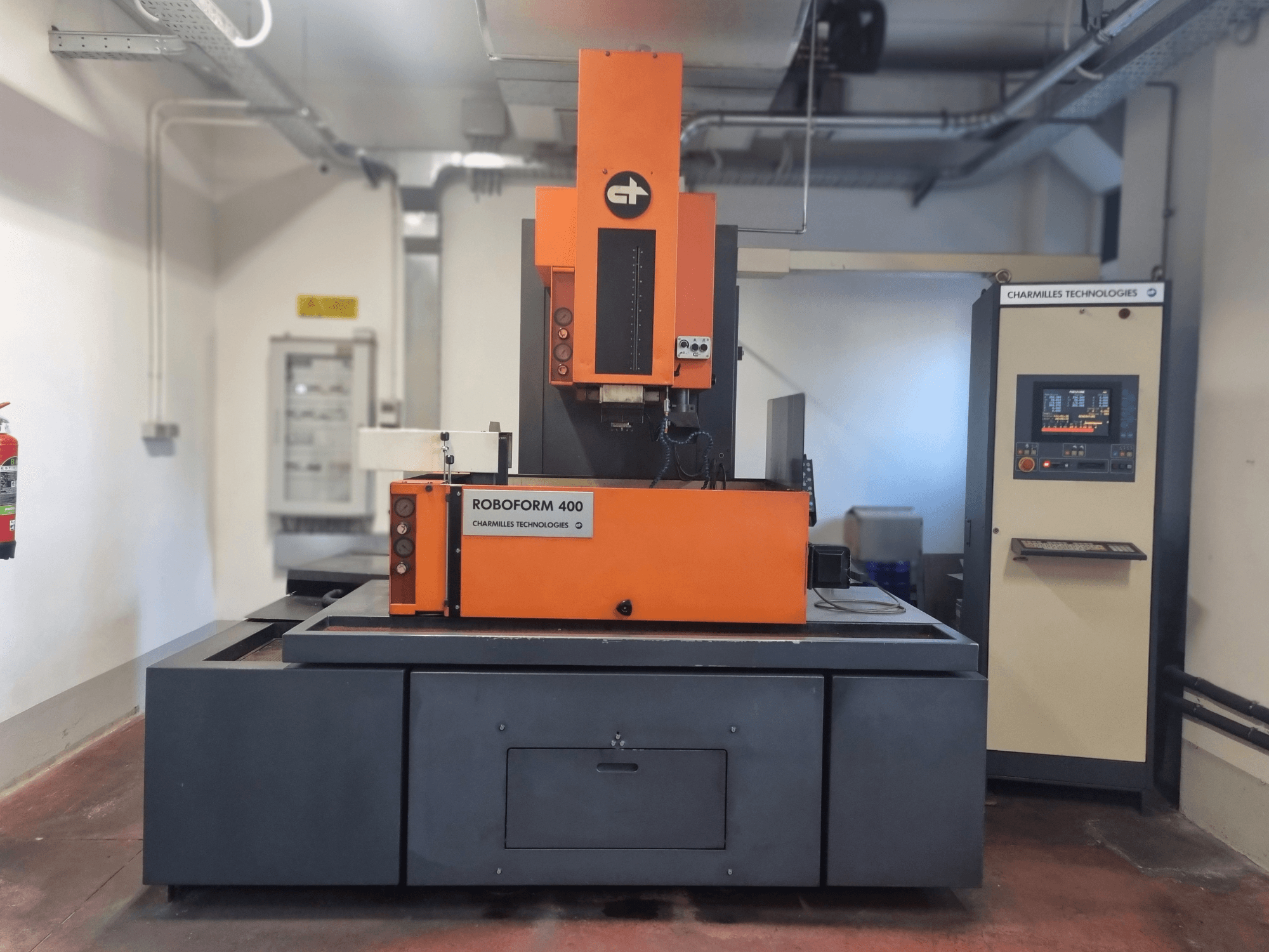 Roboforn 400 machine by Charmilles Technologies, front view, featuring an orange and gray design, digital control panel visible.