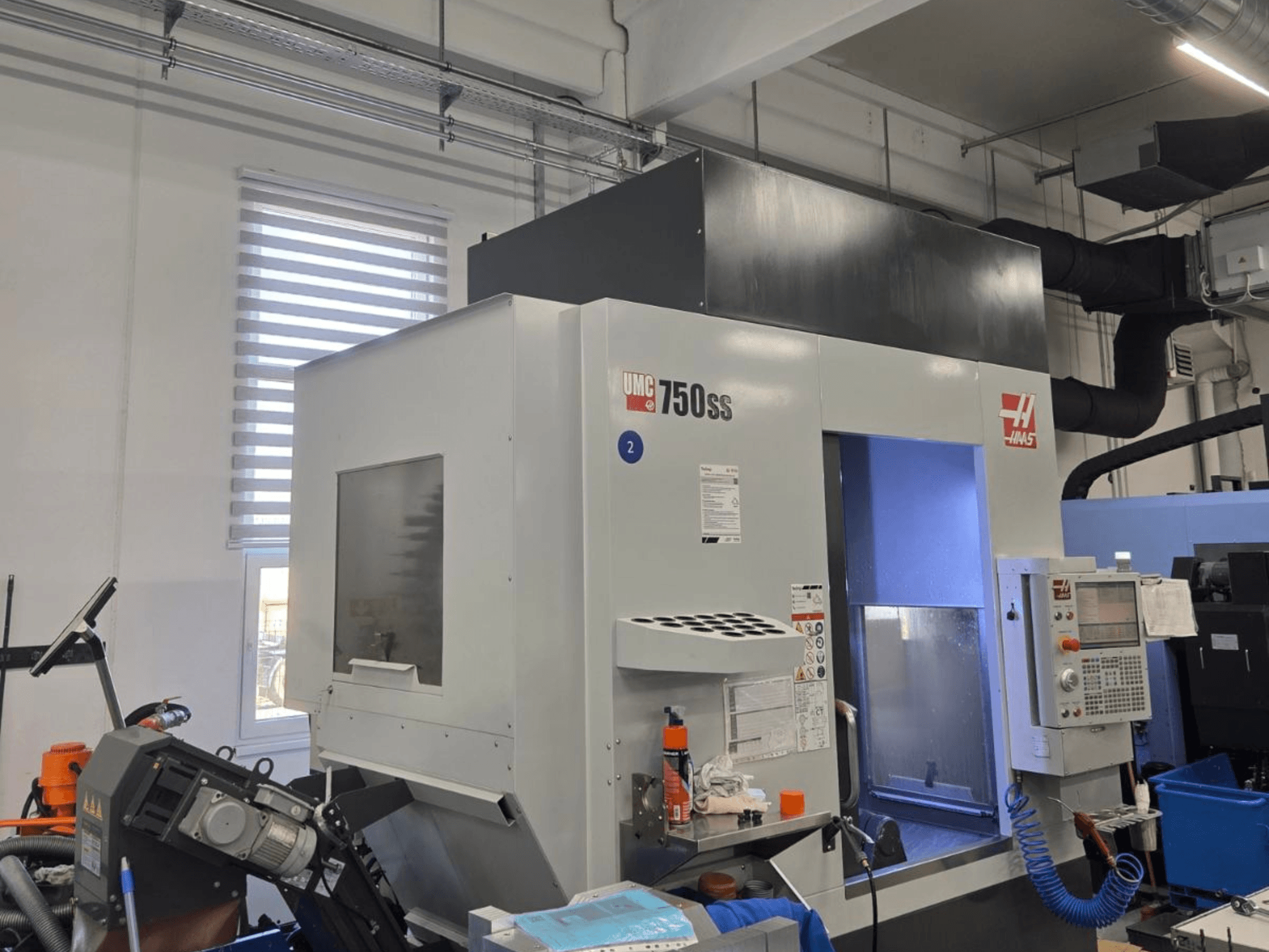 Haas UMC-750SS vertical machining center, front view, with control panel and clear access to machining area.