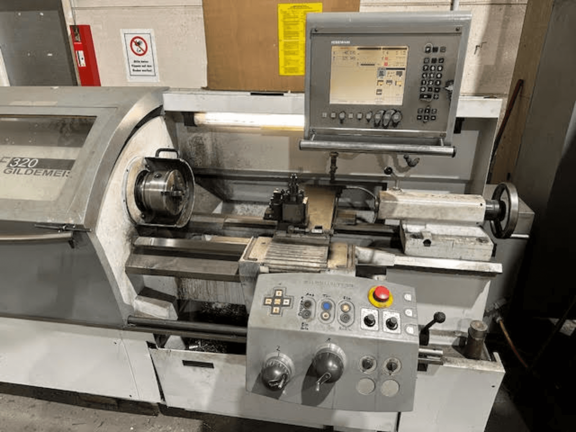 HERMLE NEF 320 horizontal turning machine, front view showcasing control panel, tooling area, and metal workpiece setup.
