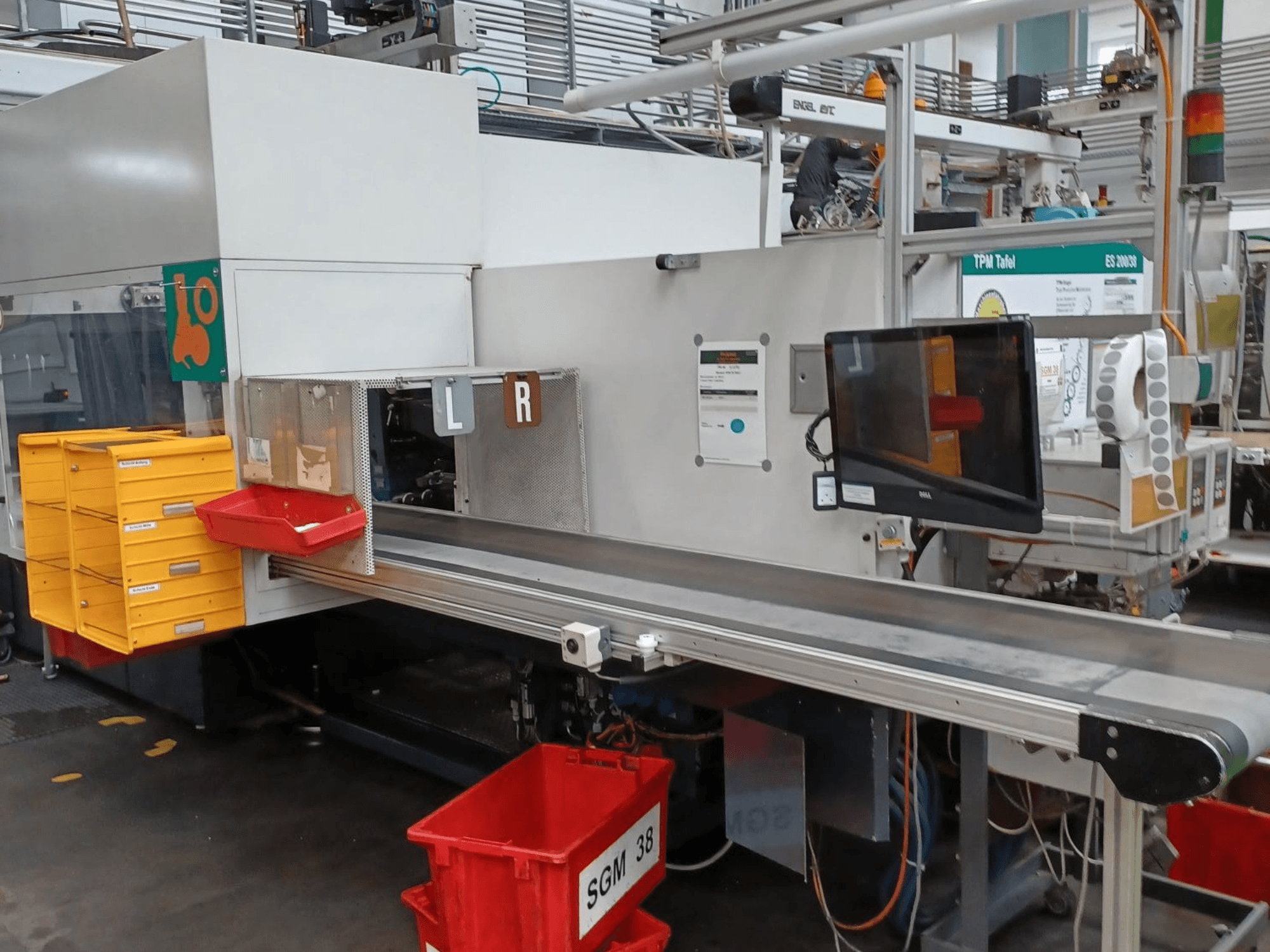 Industrial sorting machine with yellow and red bins, side view, featuring a control monitor and labeled compartments for sorting.