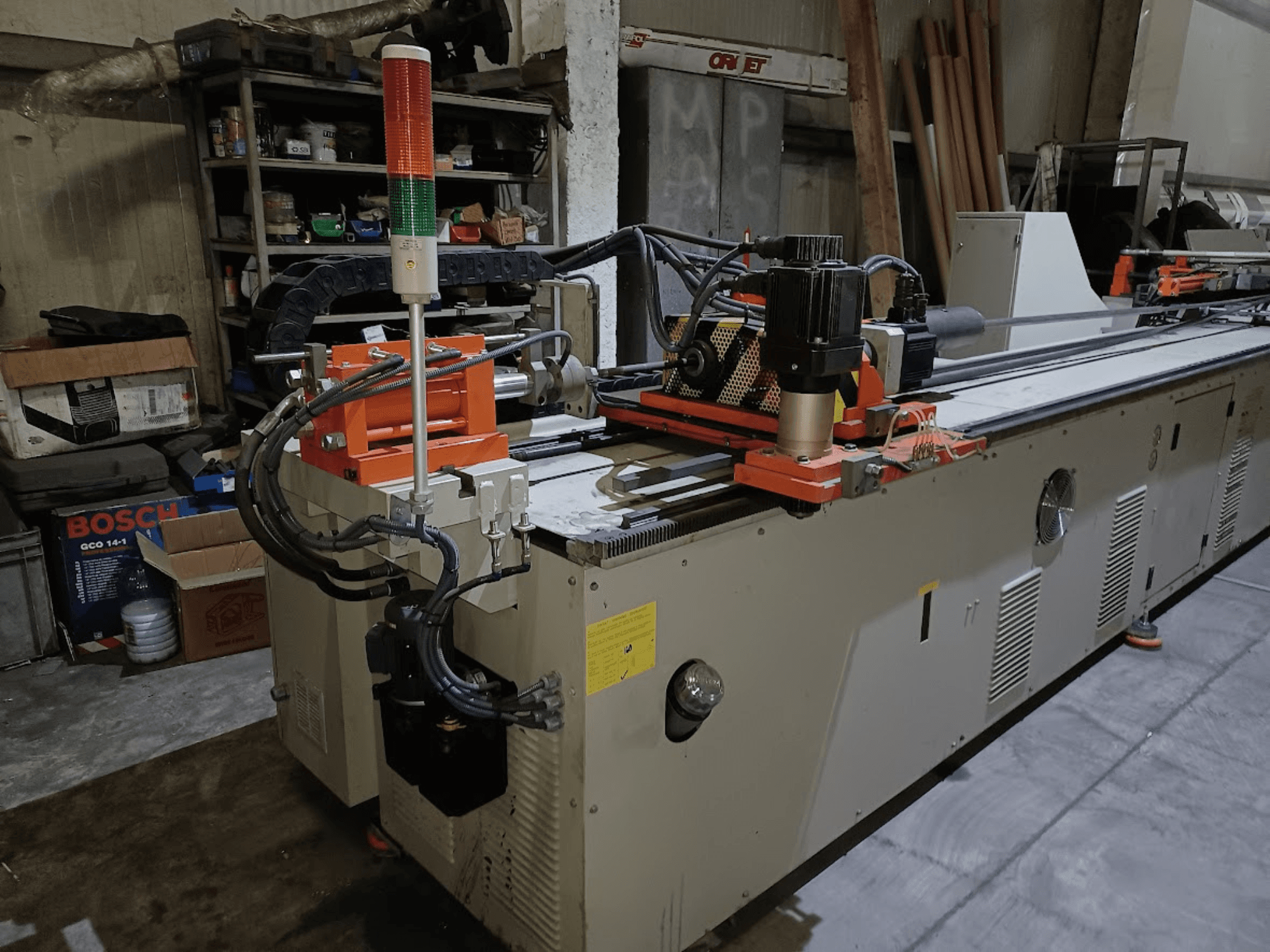 Die bending machine CANSA CNC 51 R1, side view, showing control panel, motor, and indicator lights in a workshop setting.