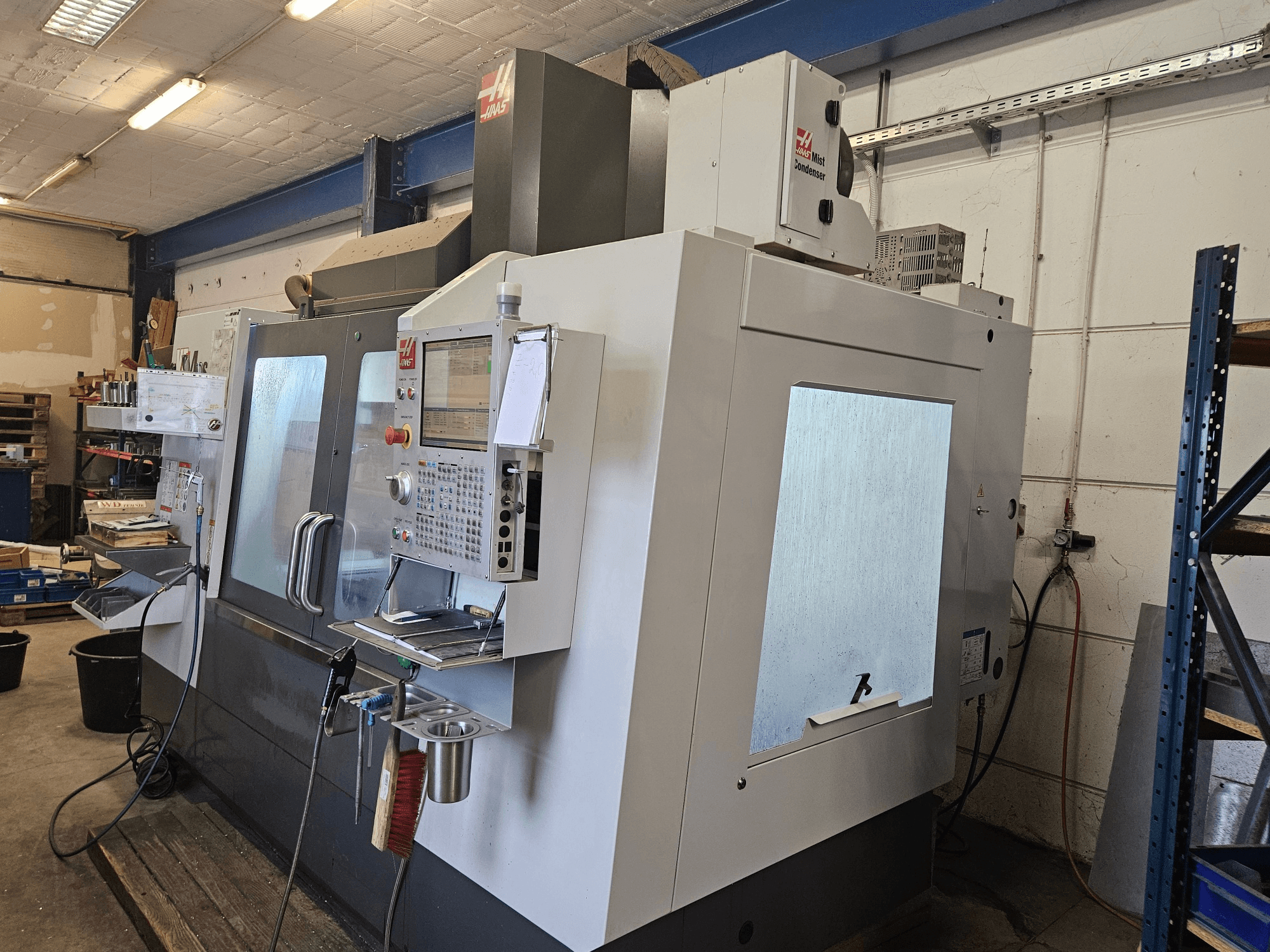 HAAS VF-4SS vertical machining center in front view, featuring a control panel and large viewing windows.