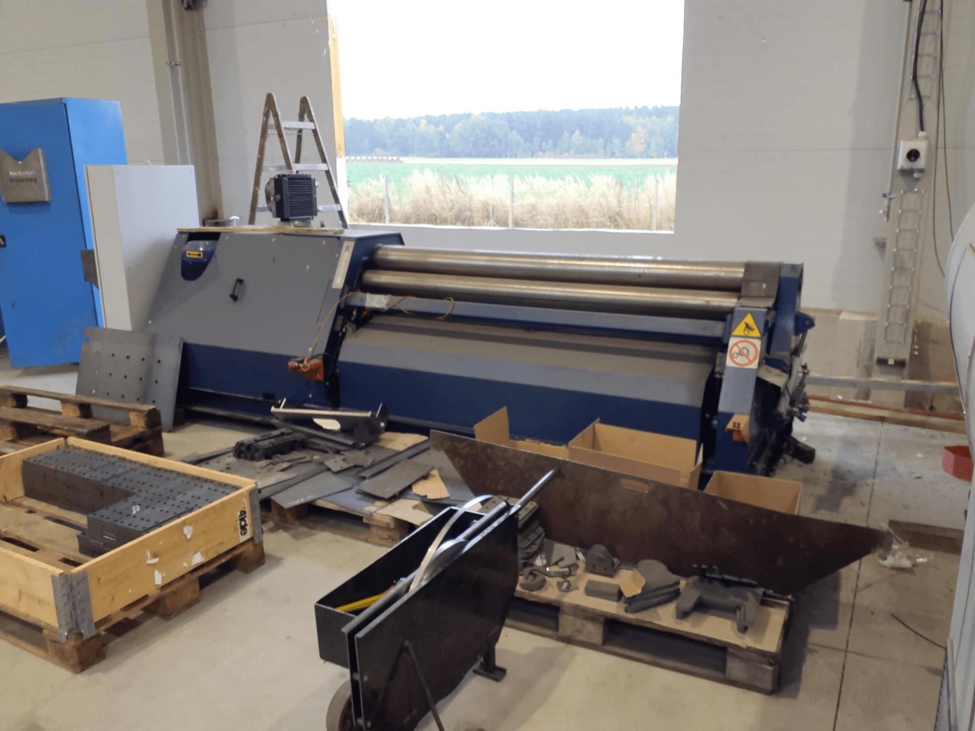 FACCIN 4HEL-2017 Plate Rolling Machine in a workshop, front view with metal parts and tools scattered around.