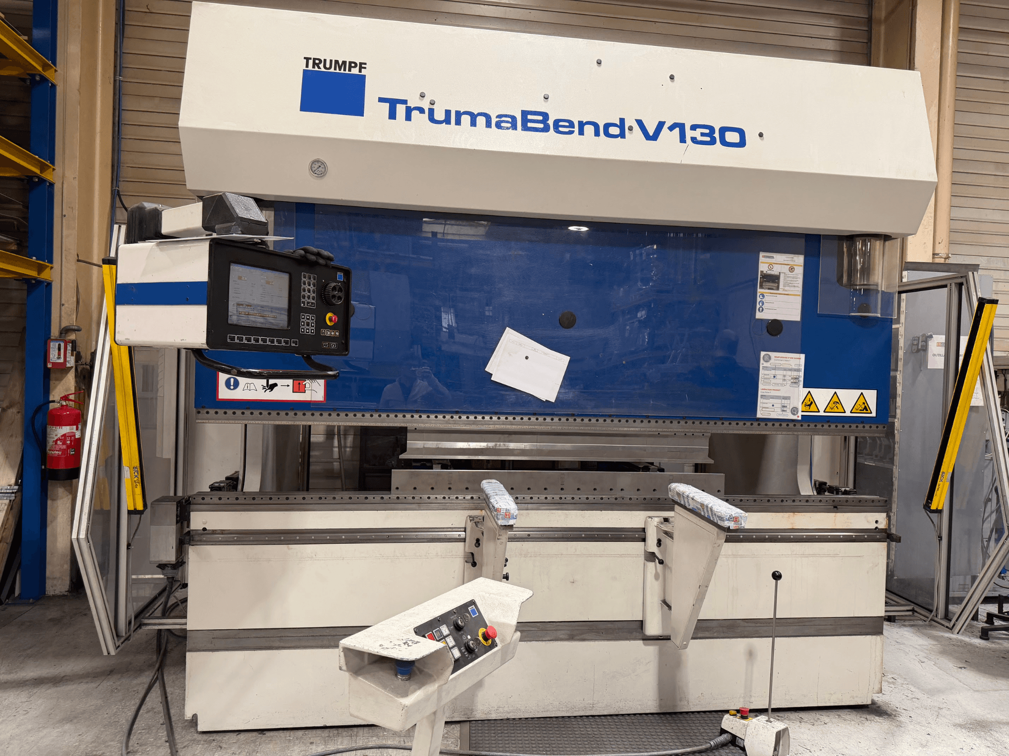 TRUMPF TrumaBend V130 press brake in a factory setting, featuring a control panel and safety features, front view.