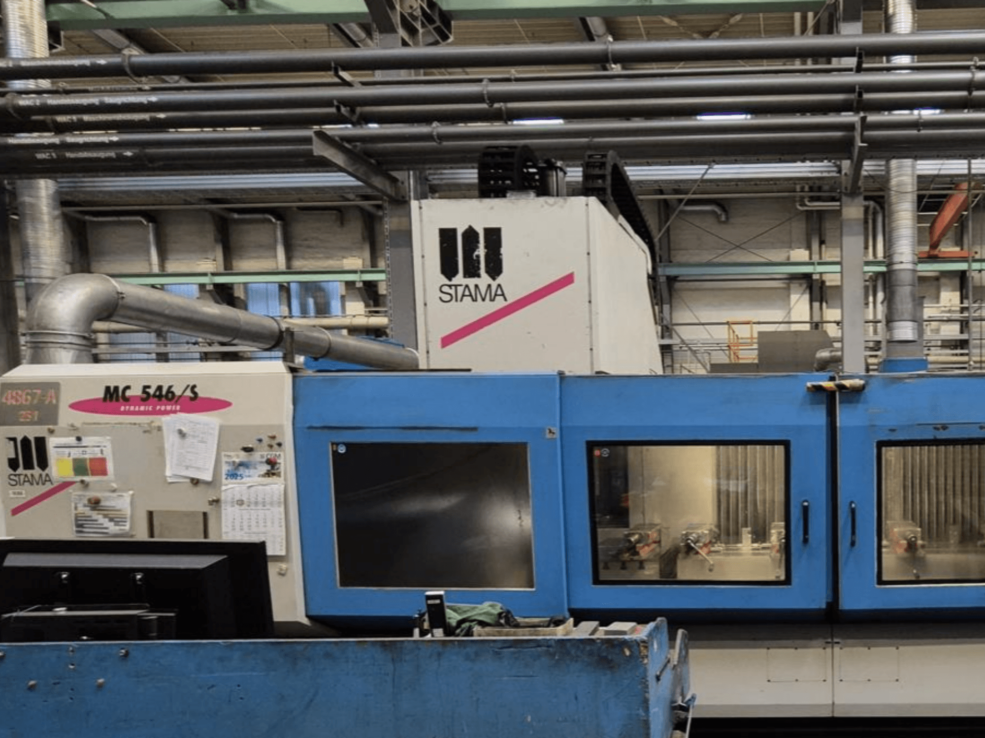Front view of STAMA MC 546/S vertical machining centre, showcasing control panel and machining area with visible tools.