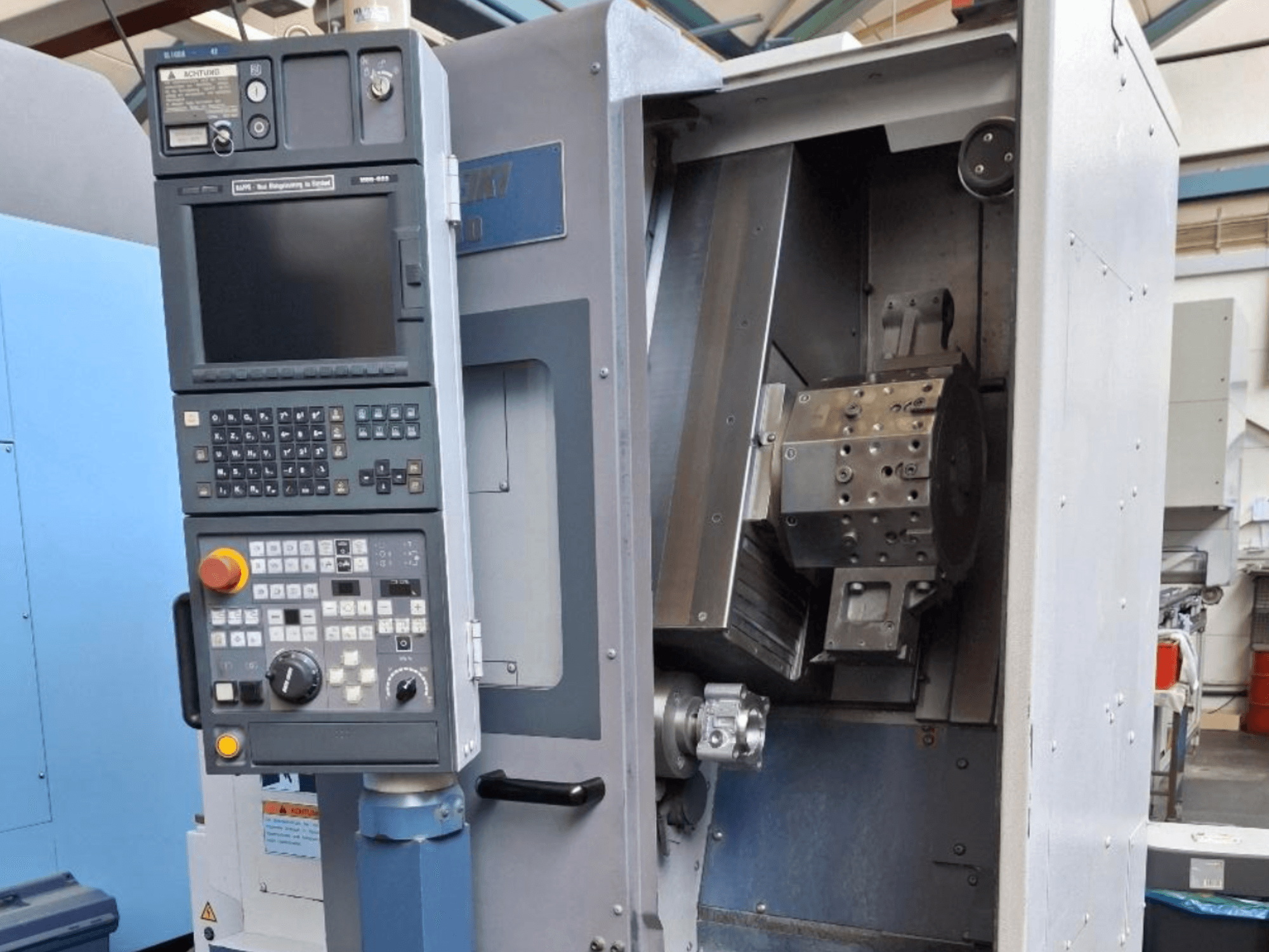 MORI SEIKI SL 1000 horizontal turning machine front view, featuring control panel and detailed internal mechanism.