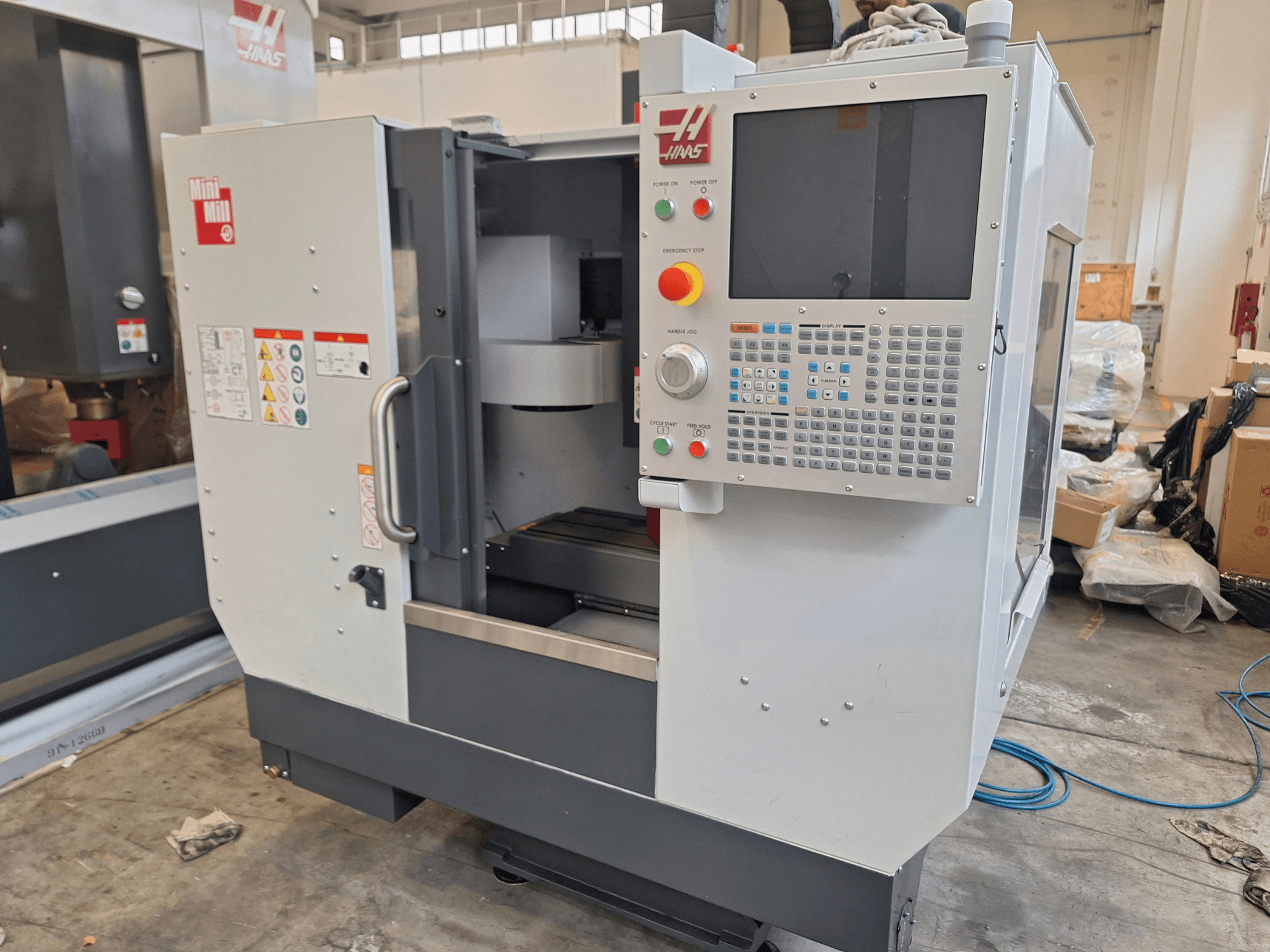 HAAS Mini Mill vertical machining center from a front view, featuring a control panel with buttons and a display screen.