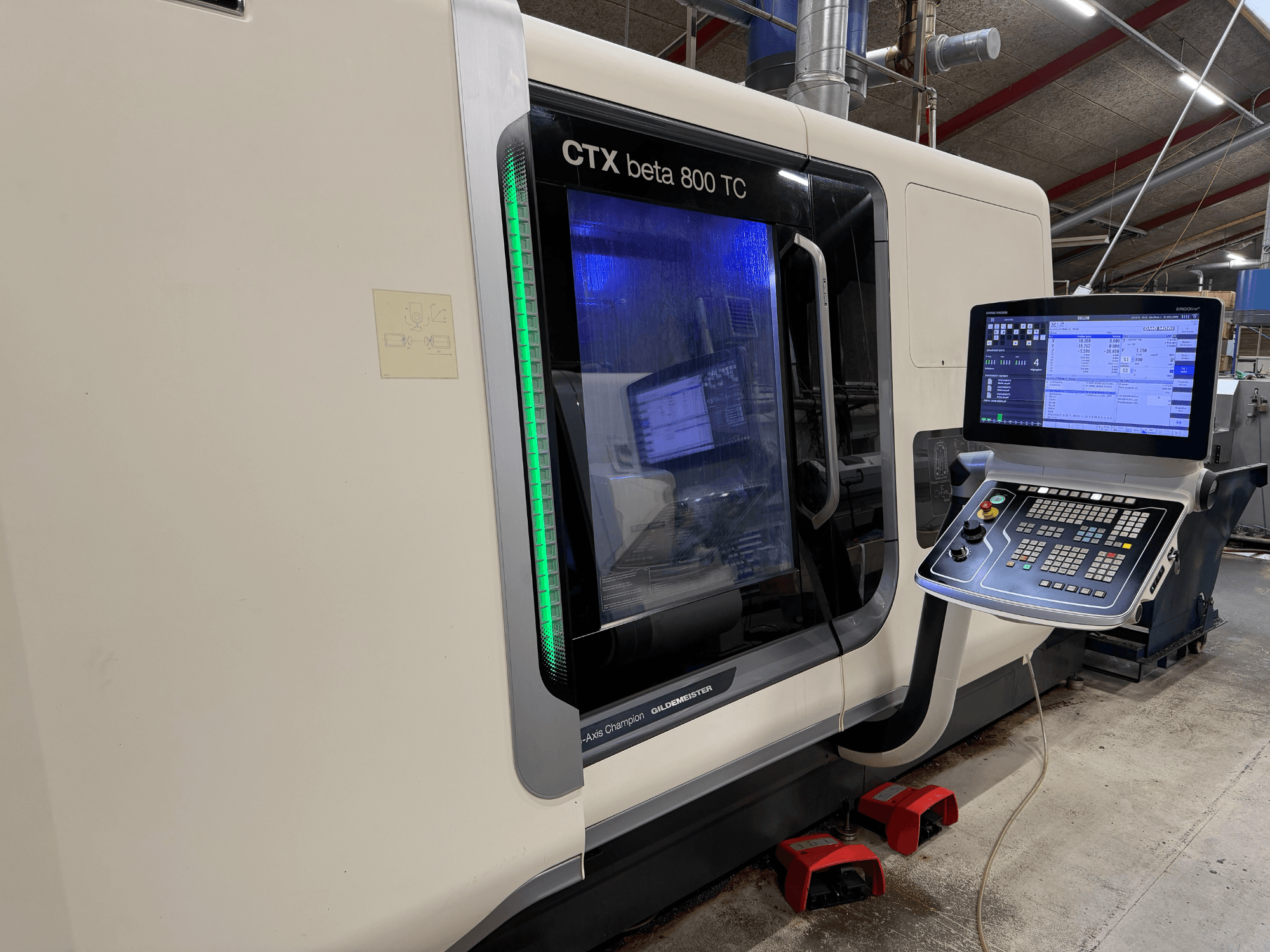 CTX beta 800 TC CNC machine in side view, featuring a digital control panel and illuminated green safety indicator.