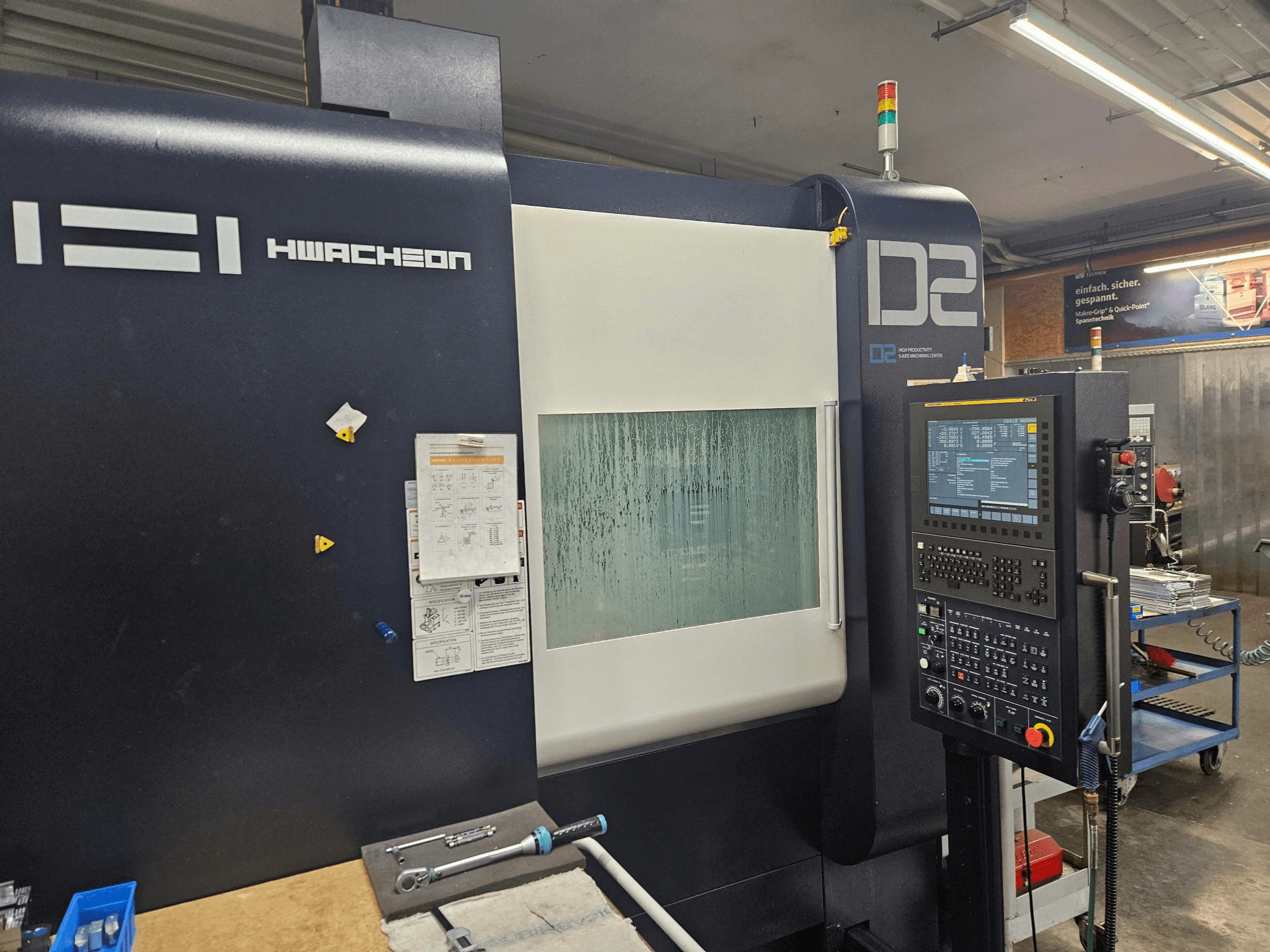 HWACHEON D2-5AX 12k vertical machining centre, front view showing control panel and misted viewing window.