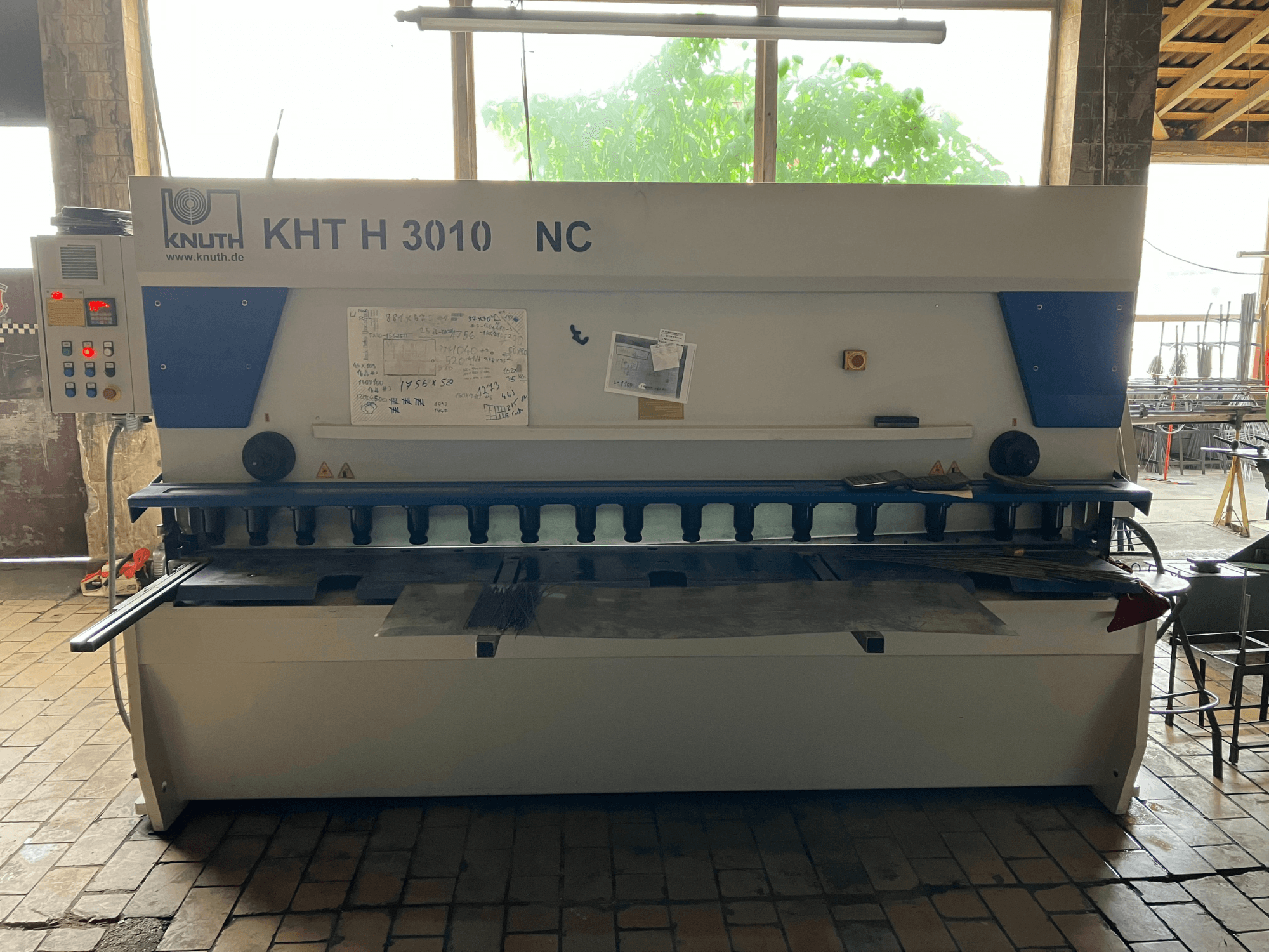 Hydraulic shearing machine KNUTH KHT H 3010 NC in front view, featuring a control panel and metal cutting area.