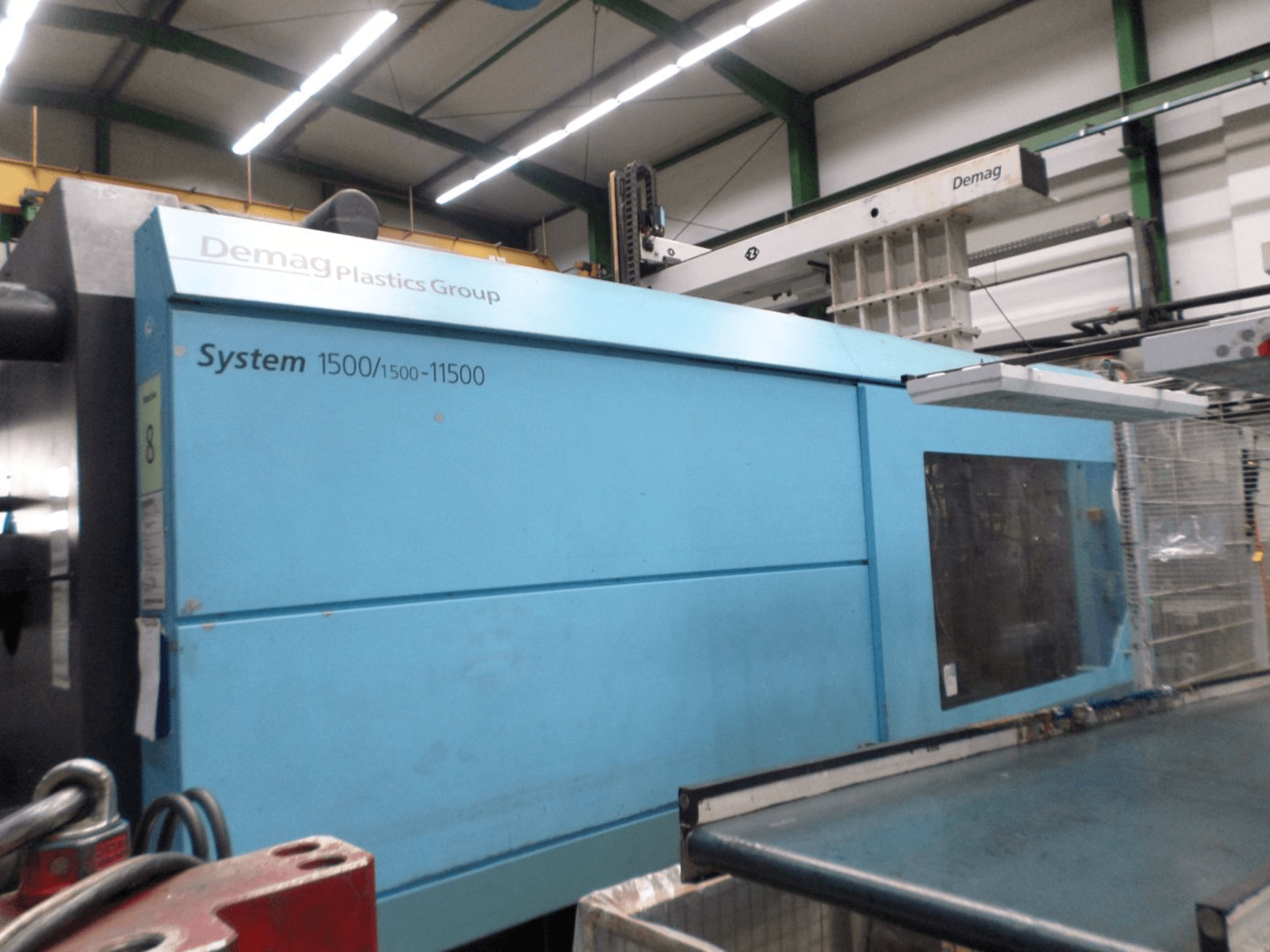 Demag D 650 hydraulic injection moulding machine in blue, side view showing System 1500/1500-11500 label and operating area.
